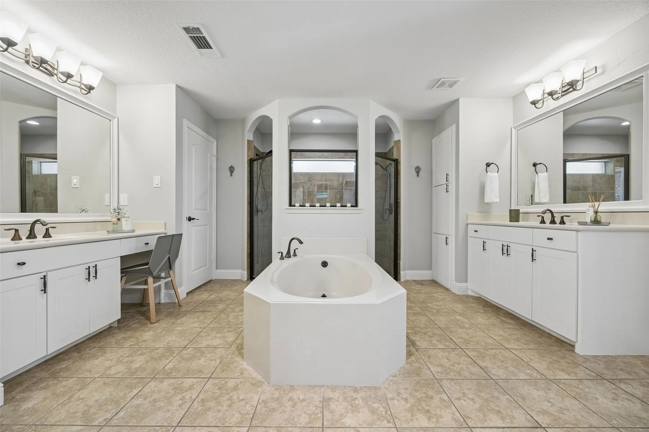 Split sinks and dual showerheads highlight the primary bath