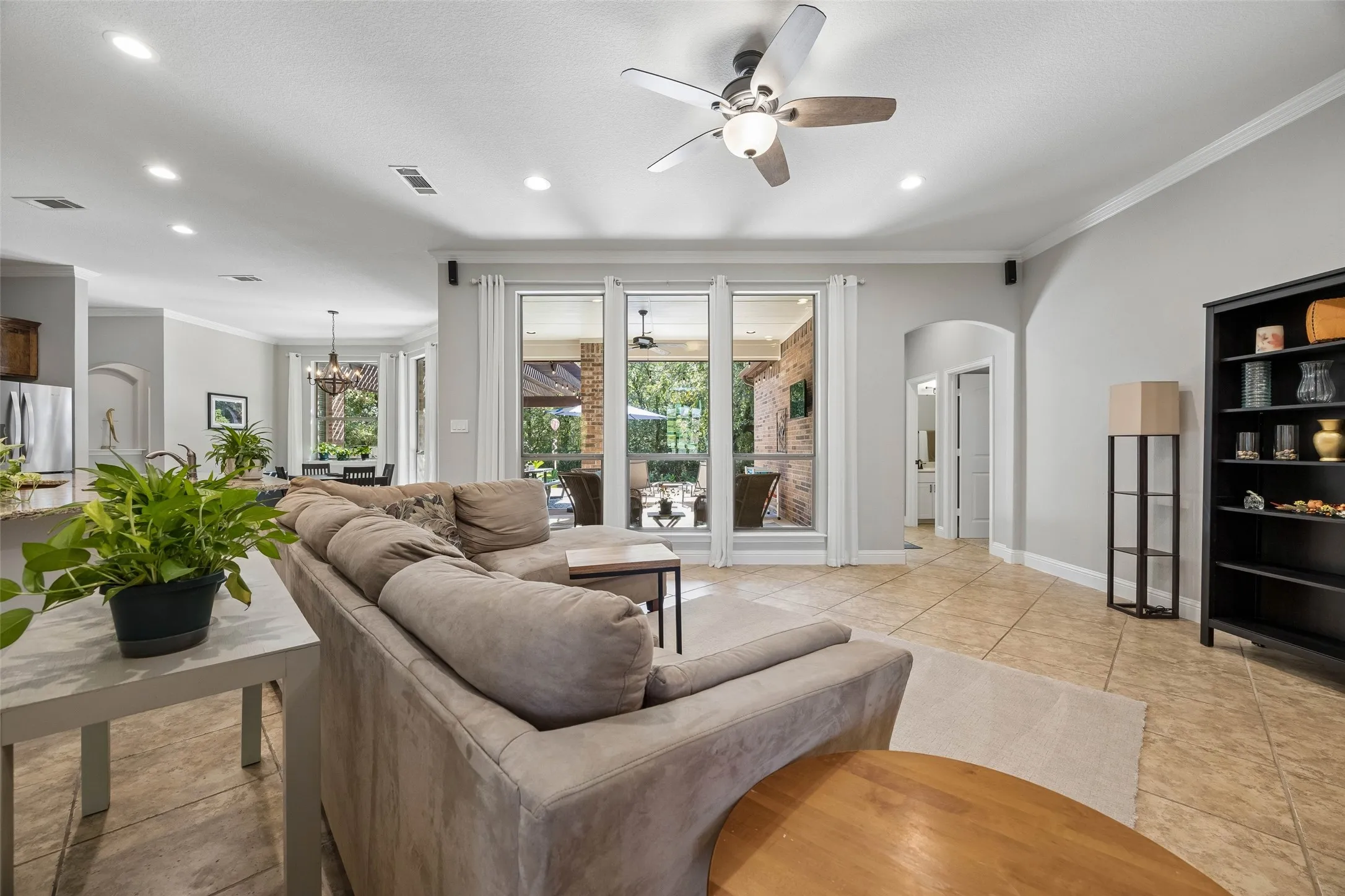 Living room opens to the kitchen and views of the pool and patio