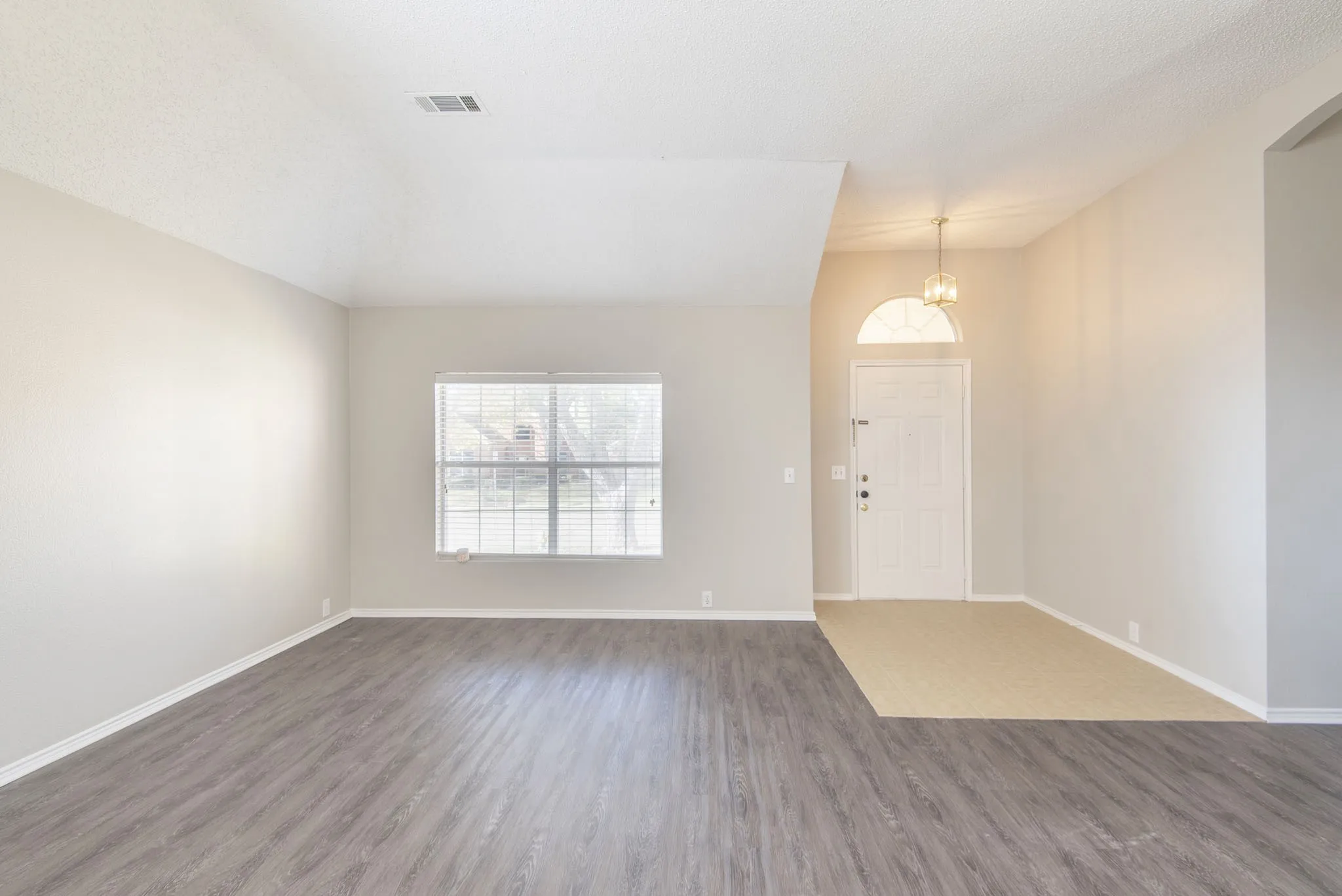 Wood-finish flooring, neutral wall tones, and overhead lighting