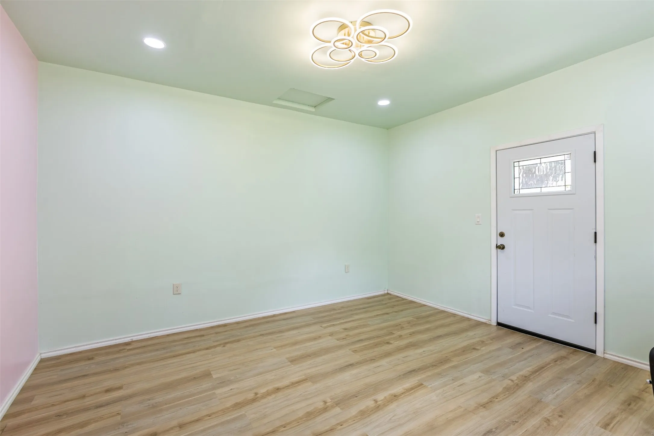 Wood-finish flooring, recessed lighting, and a decorative ceiling fixture