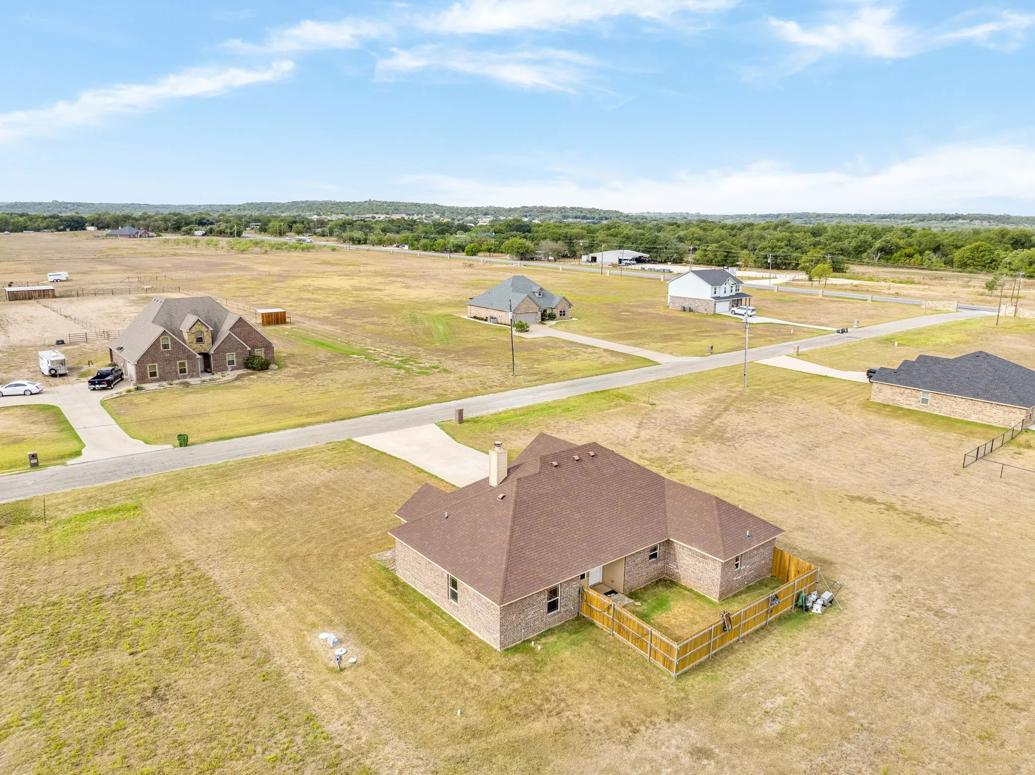 Drone view of home and fenced backyard