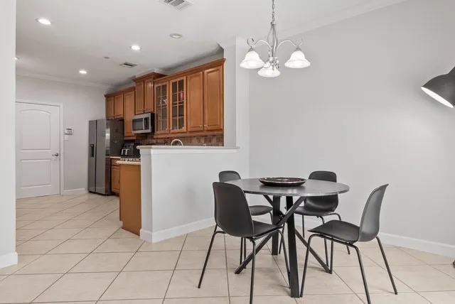 Kitchen with wood-finish cabinetry, stainless steel appliances, and a tiled backsplash