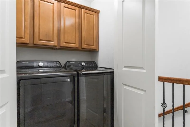 Built-in wood-finish cabinetry, solid core doors, and a wrought iron banister with wood handrail