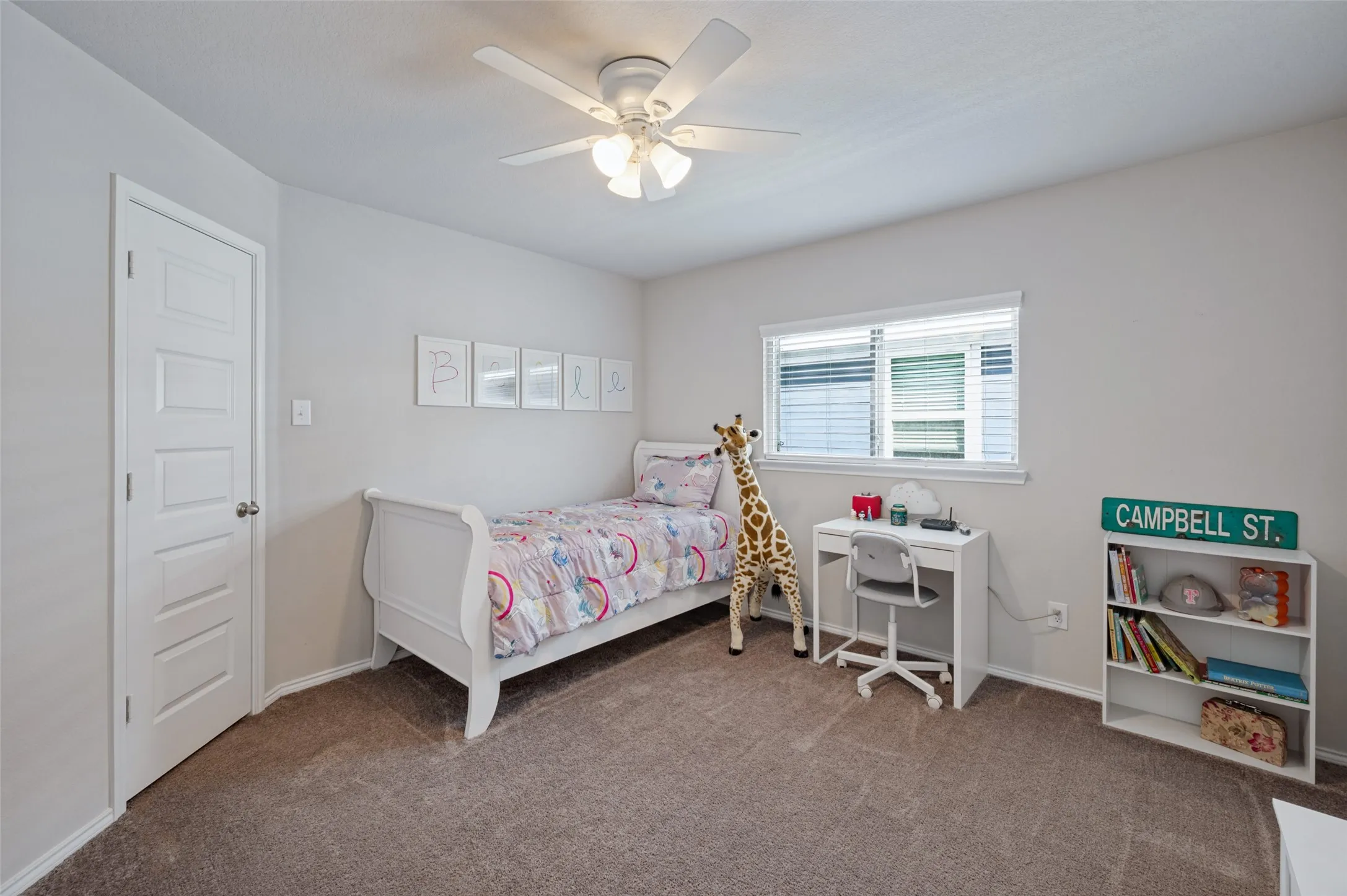 Carpeted room featuring a white ceiling fan with integrated lighting, a single window with blinds, and a paneled white door