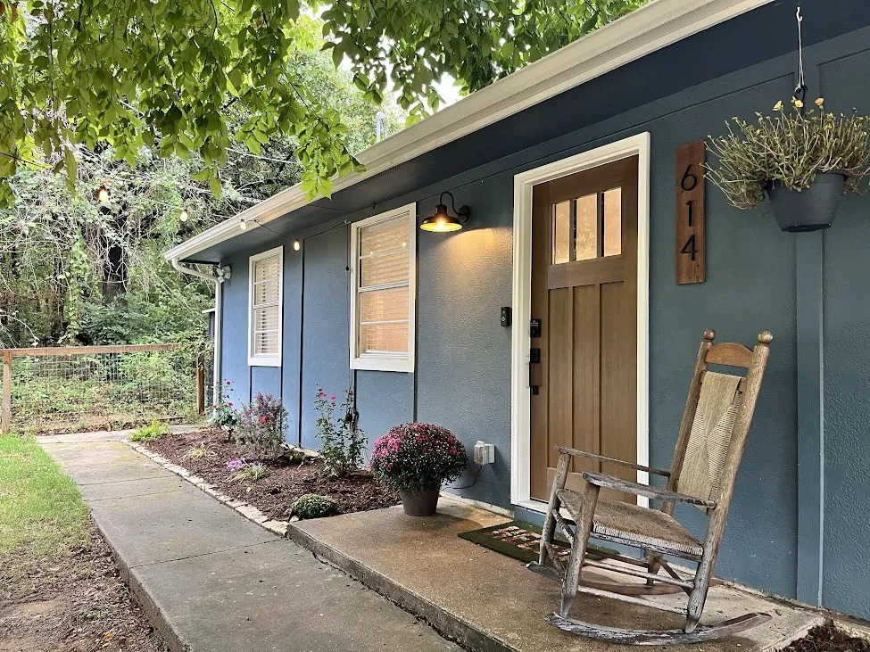 Front exterior with blue siding, white trim windows, and a craftsman-style front door