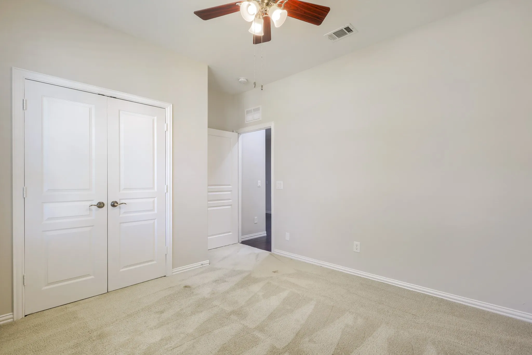 Light-toned carpeted flooring, white trim, and a ceiling fan with integrated lighting