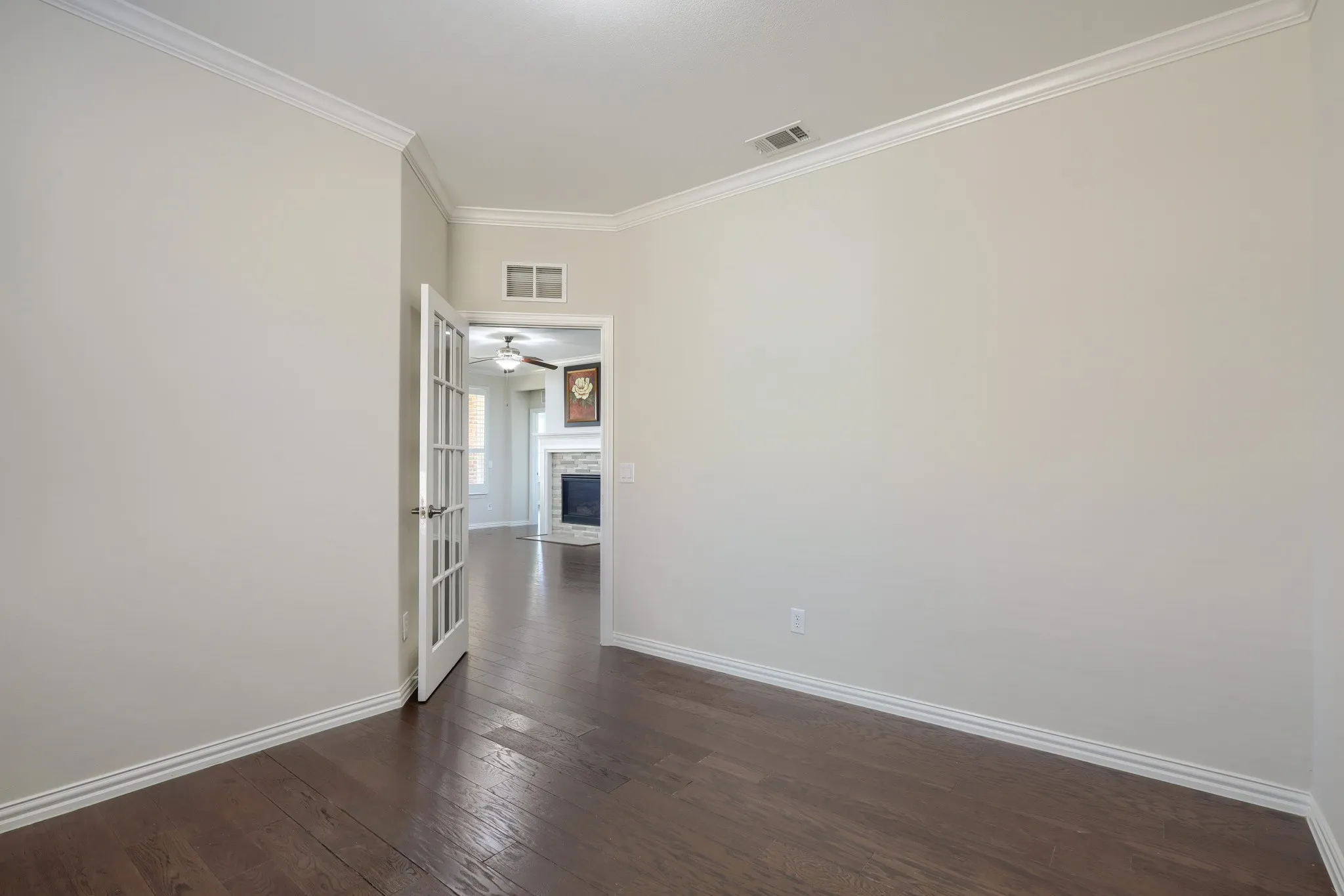 Wood-finish flooring, crown molding, and white trim accents