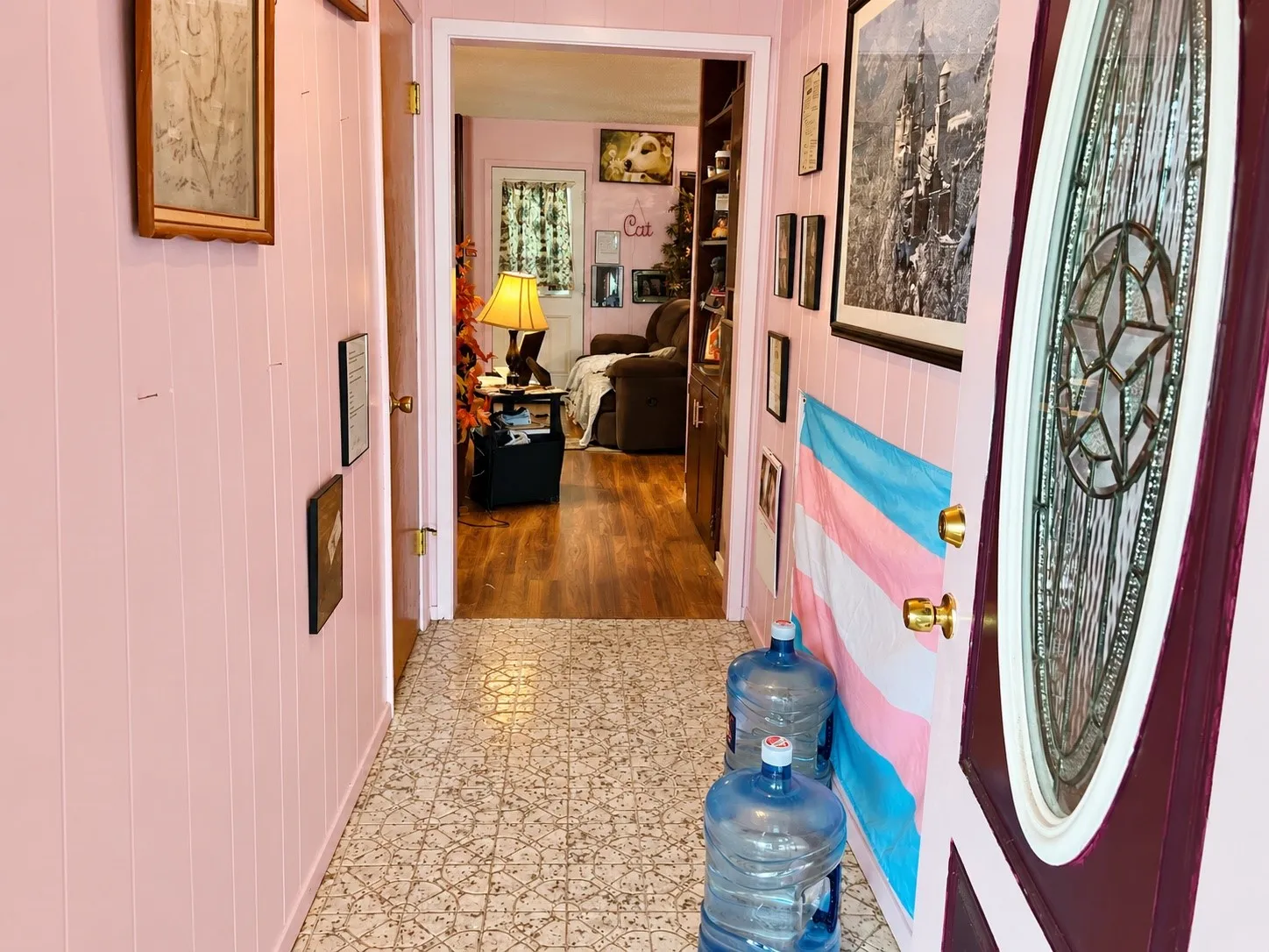 Entryway featuring vertical wall paneling, patterned flooring, and a decorative door with an oval-shaped glass insert