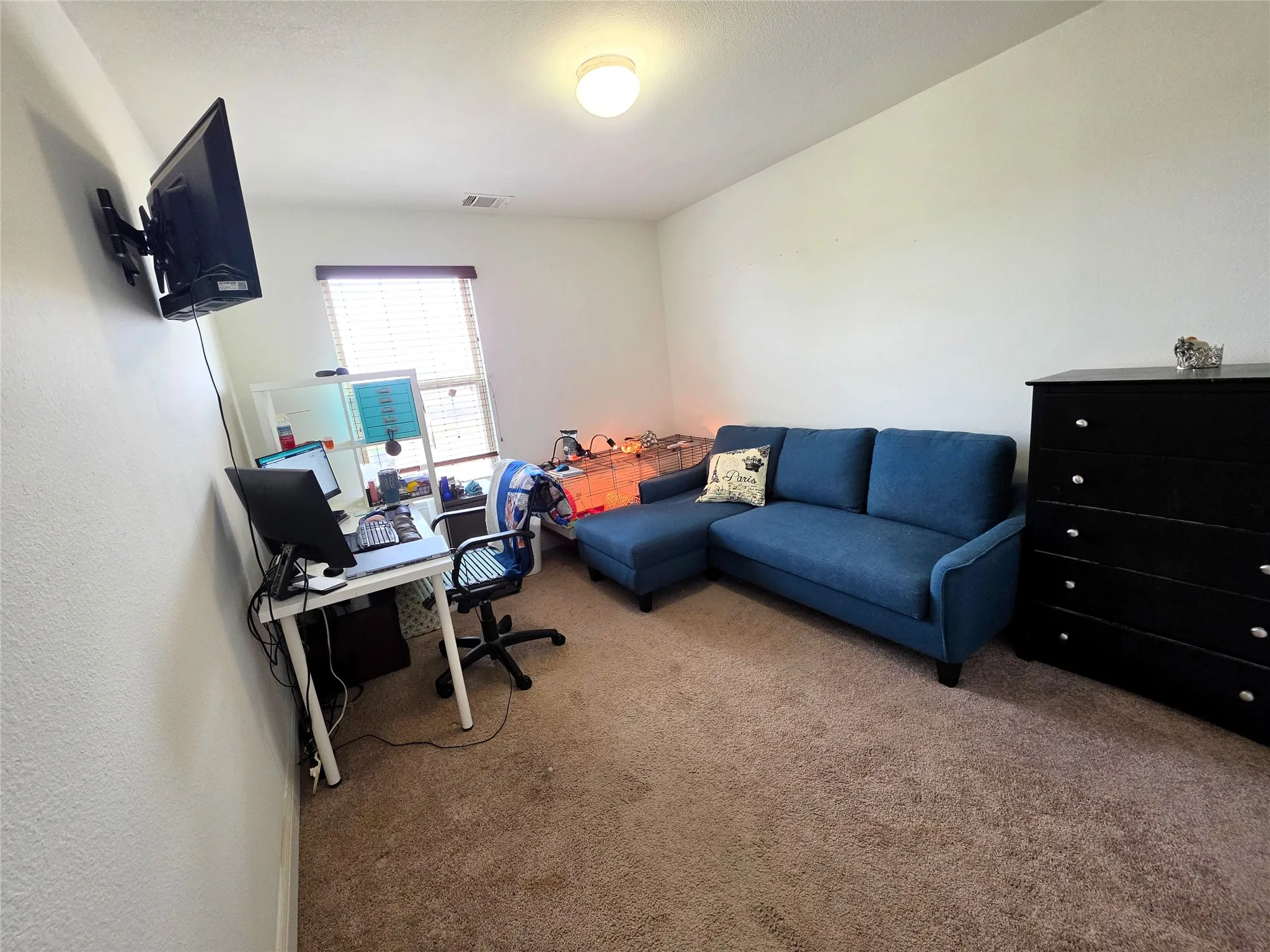 Carpeted flooring, window with horizontal blinds, wall-mounted light fixture, white walls, built-in air vent