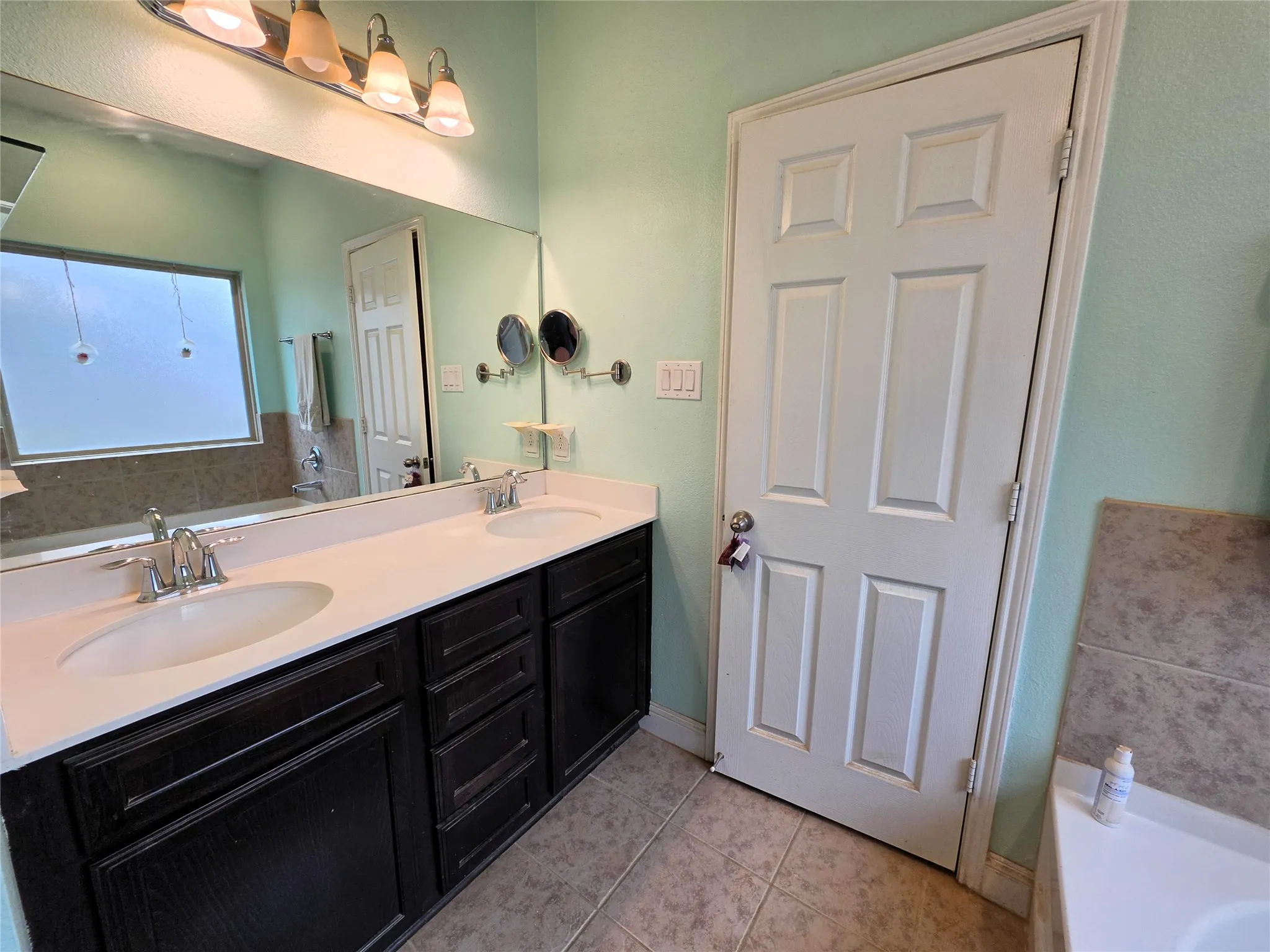 Double vanity with dual undermount sinks, chrome fixtures, and a white countertop