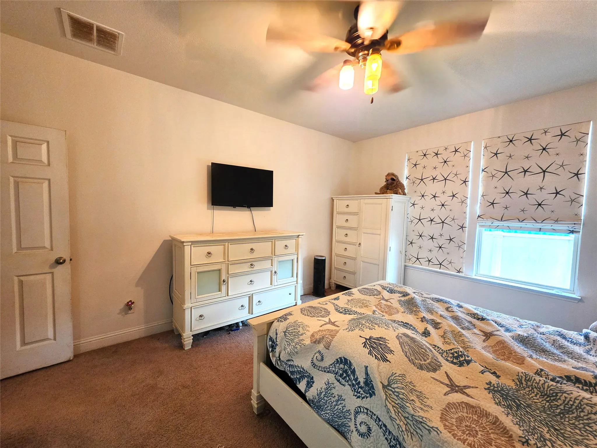 Dual windows with decorative blinds, neutral wall paint, and a ceiling fan with integrated lighting