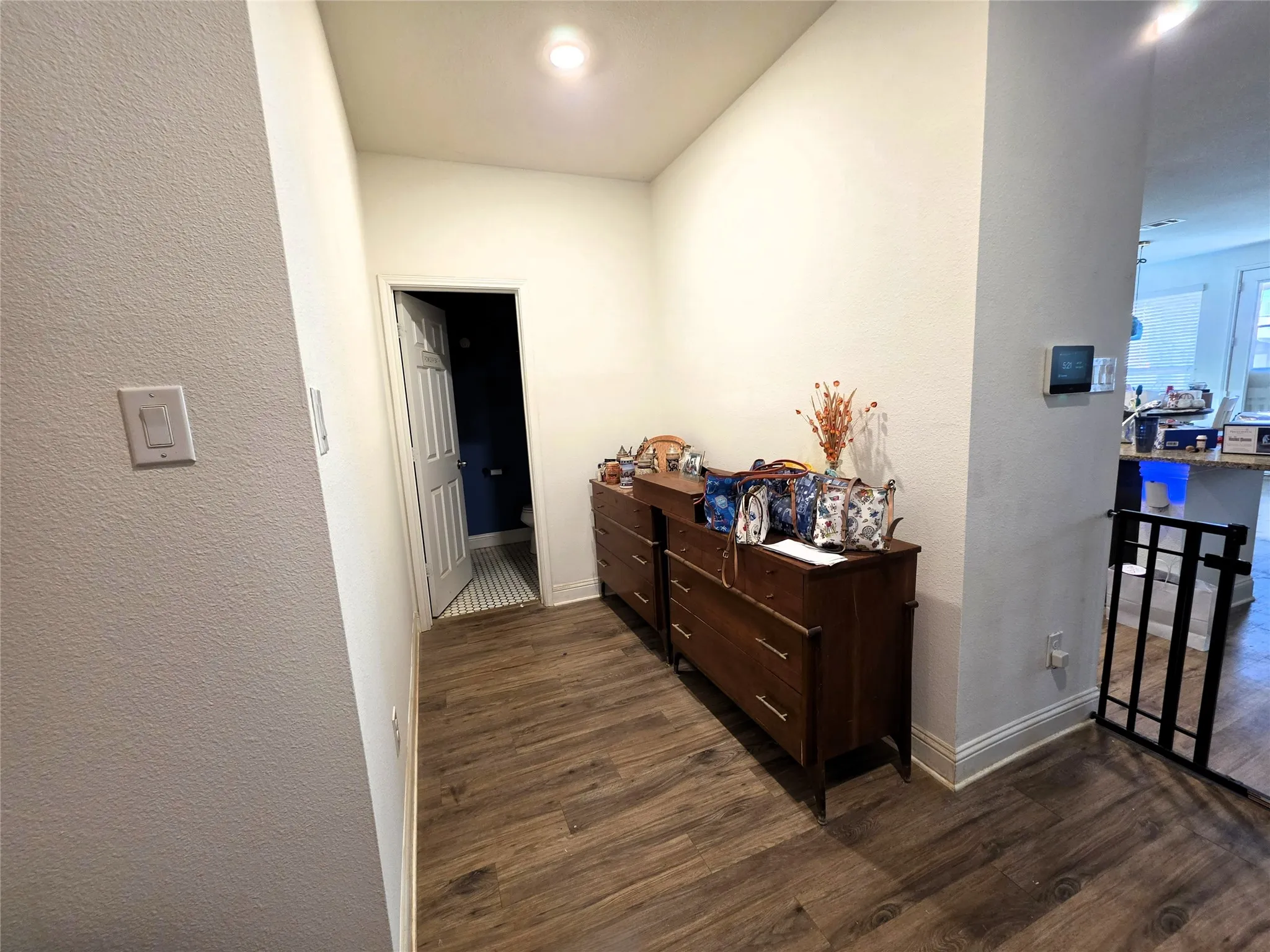 Wood-finish flooring throughout, white baseboards, and a recessed ceiling light fixture