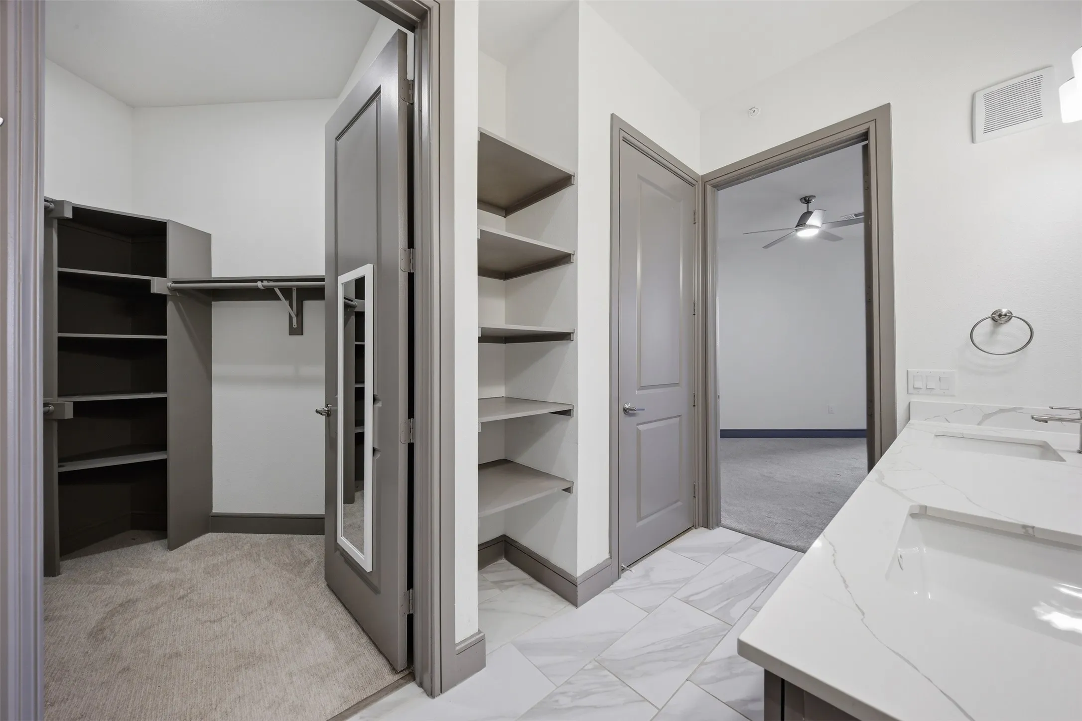 Bathroom featuring a dual vanity with white countertops, undermount sinks, and contemporary wall-mounted light fixtures