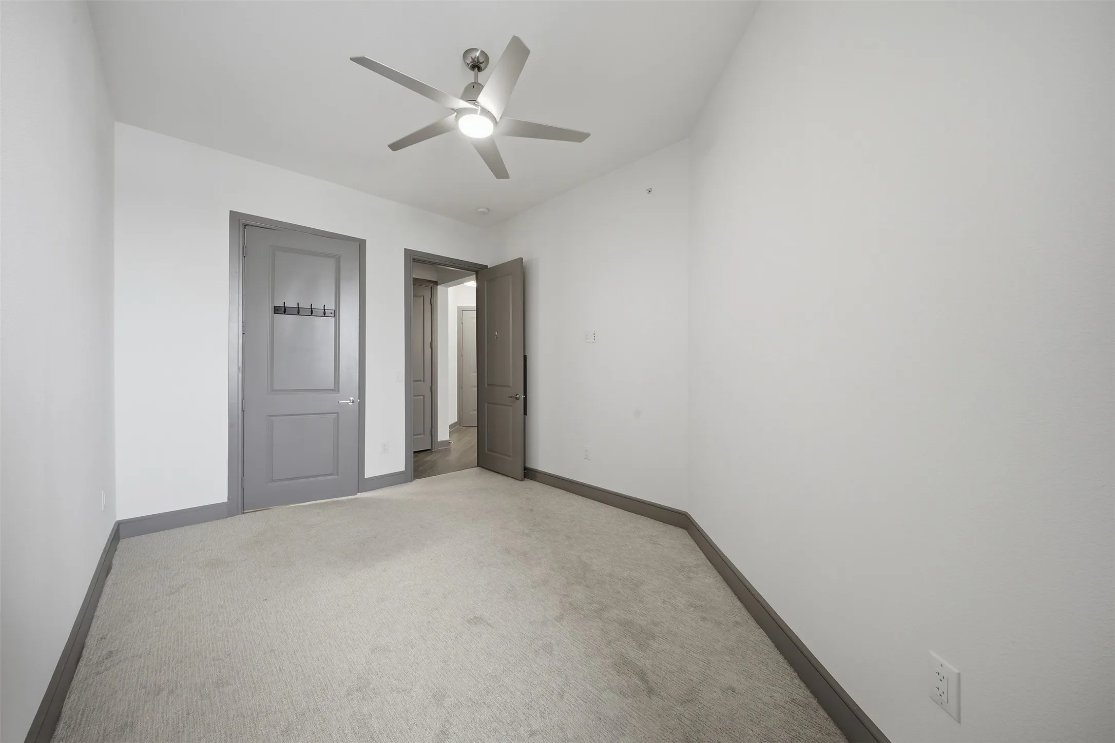 Recessed lighting, ceiling fan, and light-toned carpeting