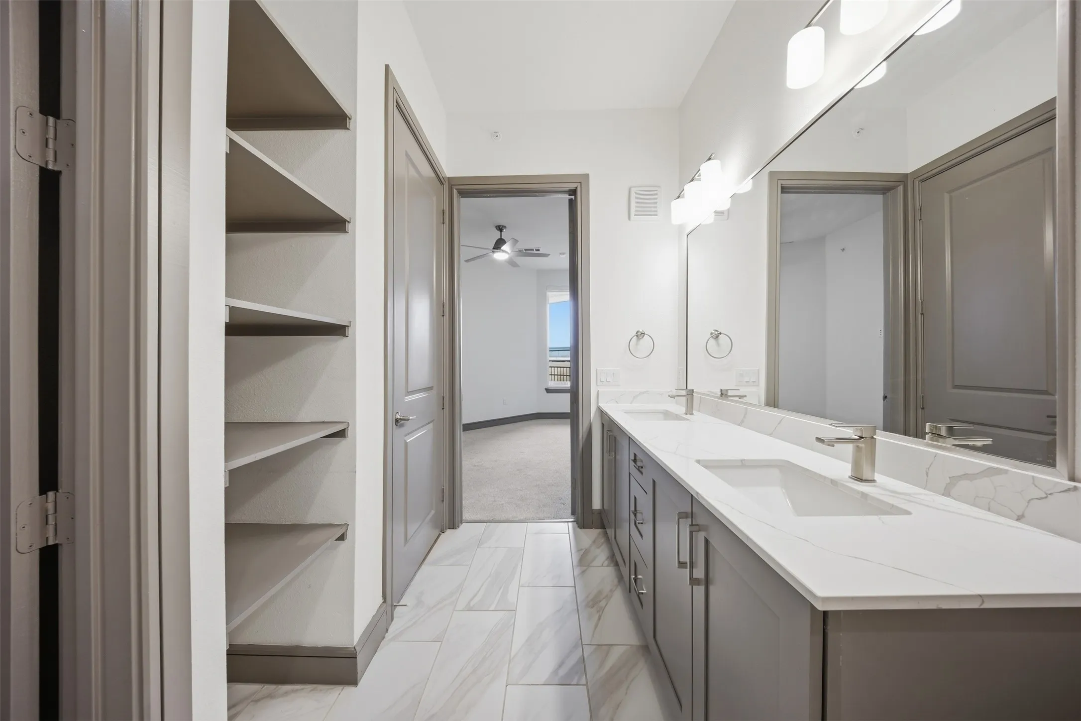 Dual vanity with undermount sinks, stone-finish countertop, and brushed nickel fixtures