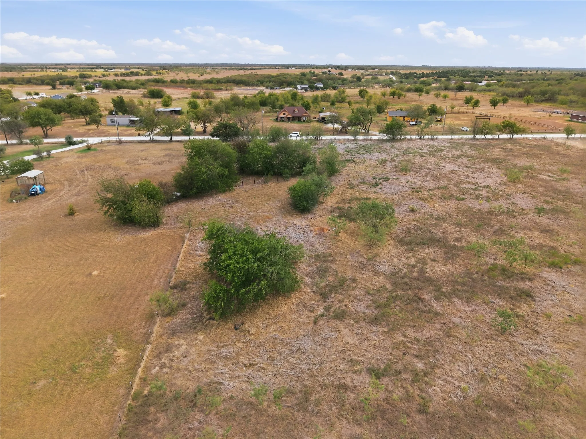 Expansive undeveloped lot with scattered mature trees and open fields