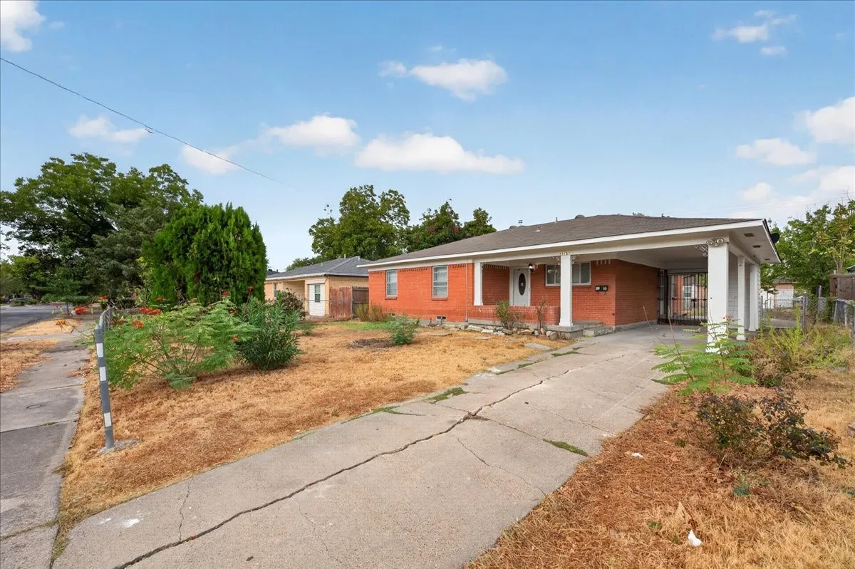 Brick exterior with covered carport, front porch, and concrete driveway