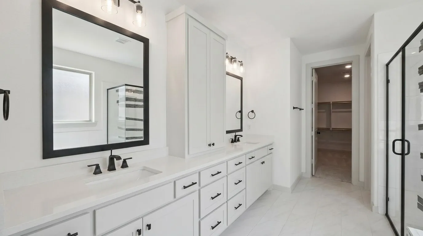 Dual vanity with white cabinetry, matte black hardware, and integrated sinks