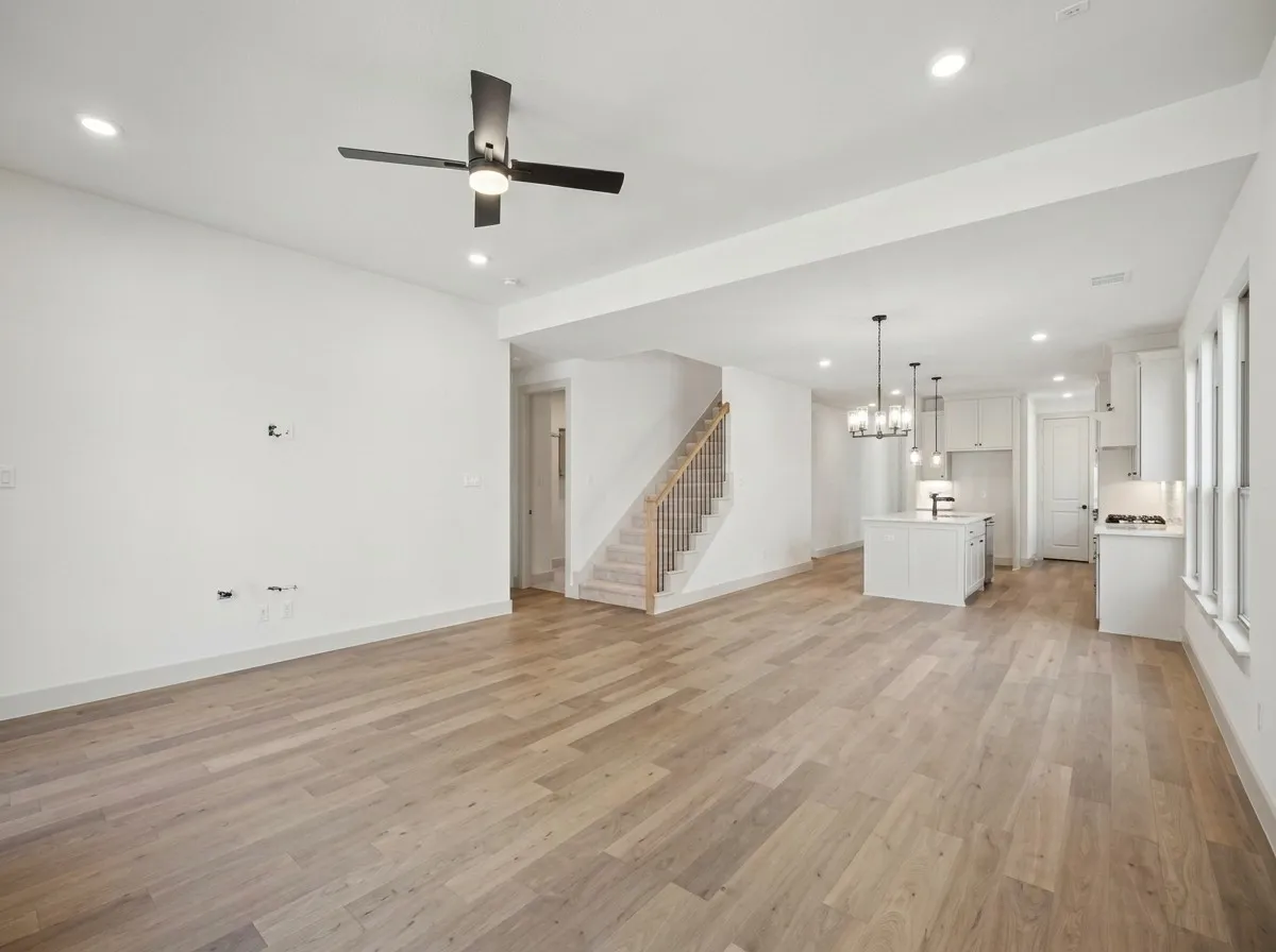Open-concept living area featuring wood-finish flooring, recessed lighting, and a modern ceiling fan