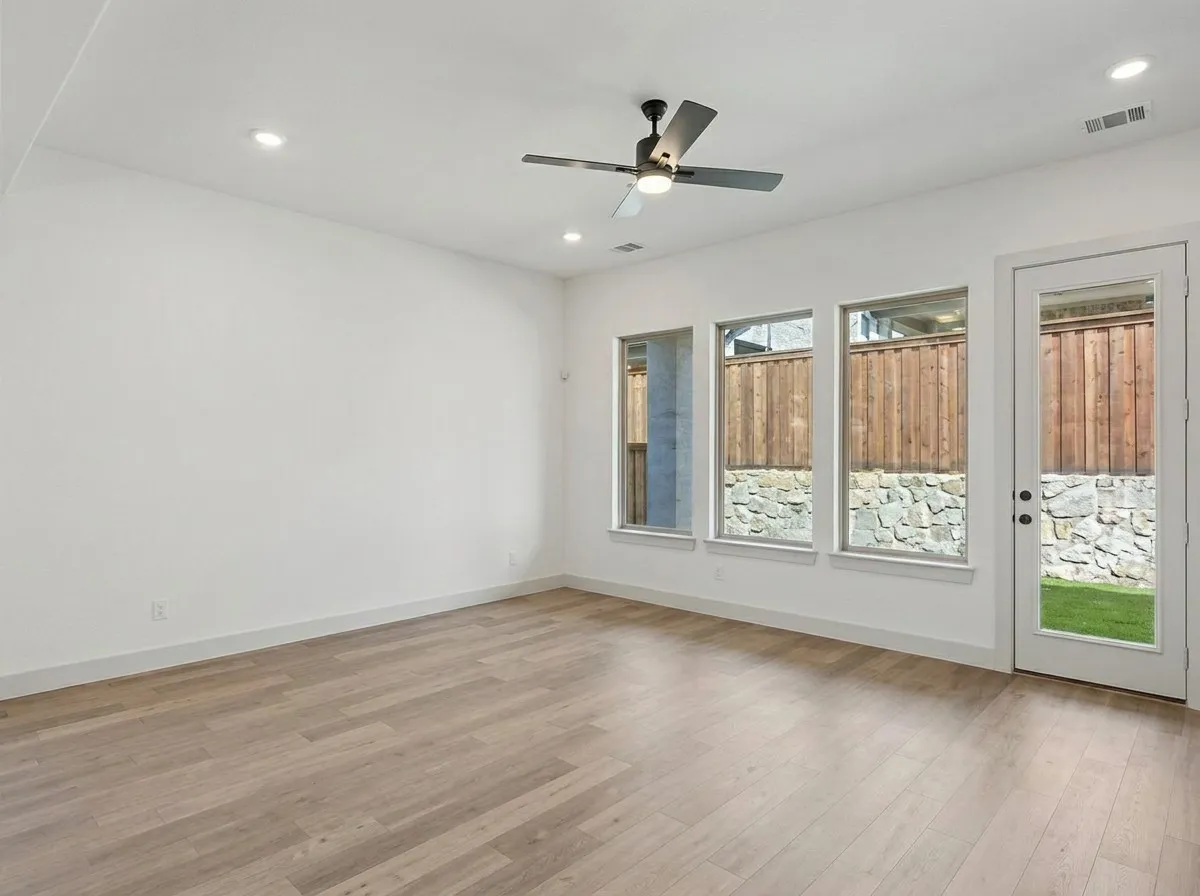 Recessed lighting, ceiling fan, wood-finish flooring, three windows, and a glass-paneled door