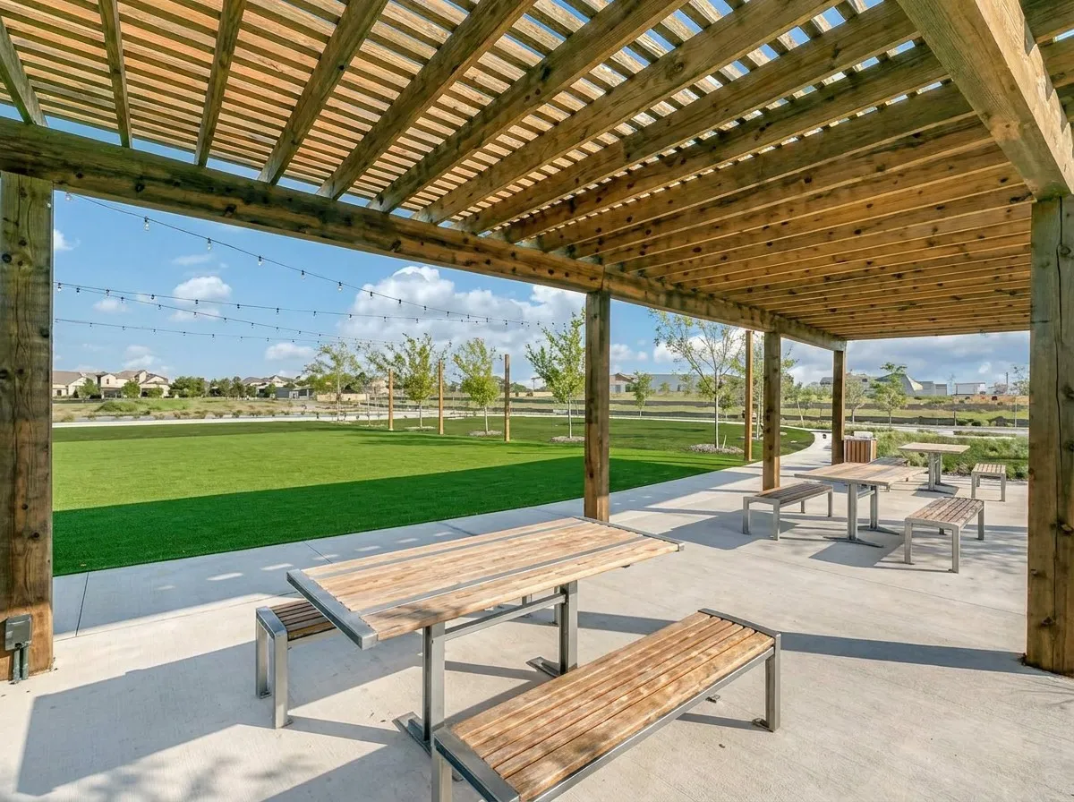 Expansive wood pergola with open slatted roof and concrete flooring