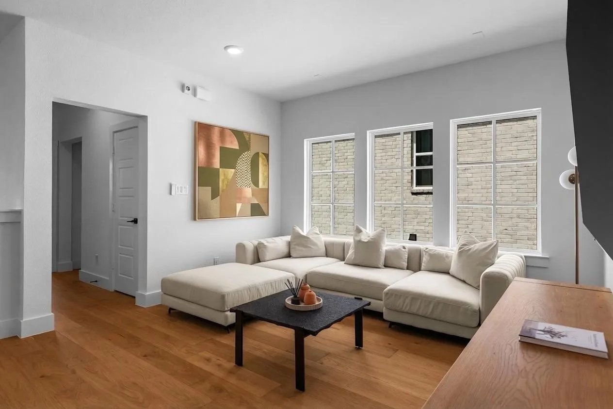 Recessed lighting, wood-finish flooring, white trim, and multiple gridded windows with white frames