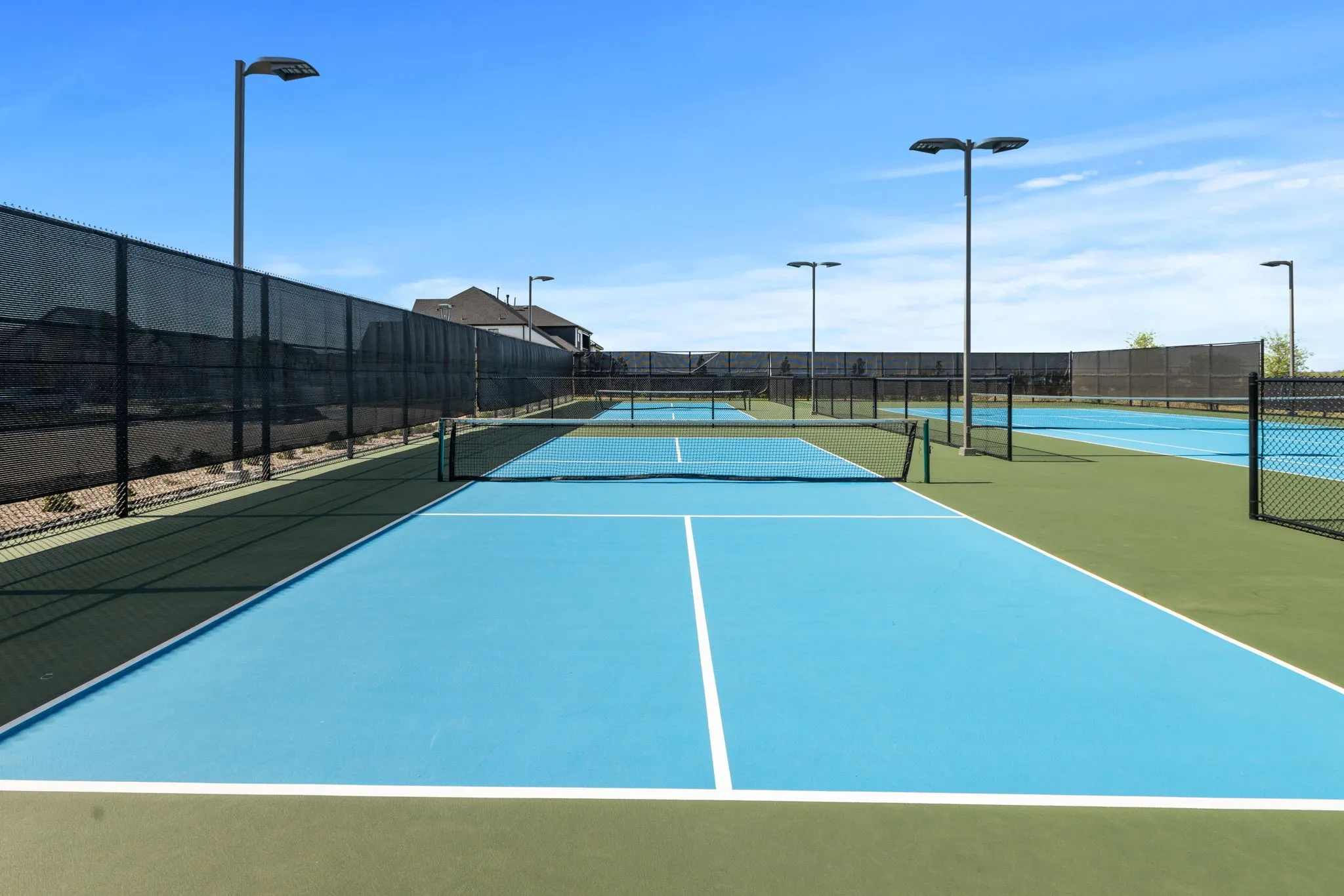 Multiple hard-surface courts with blue and green surfacing