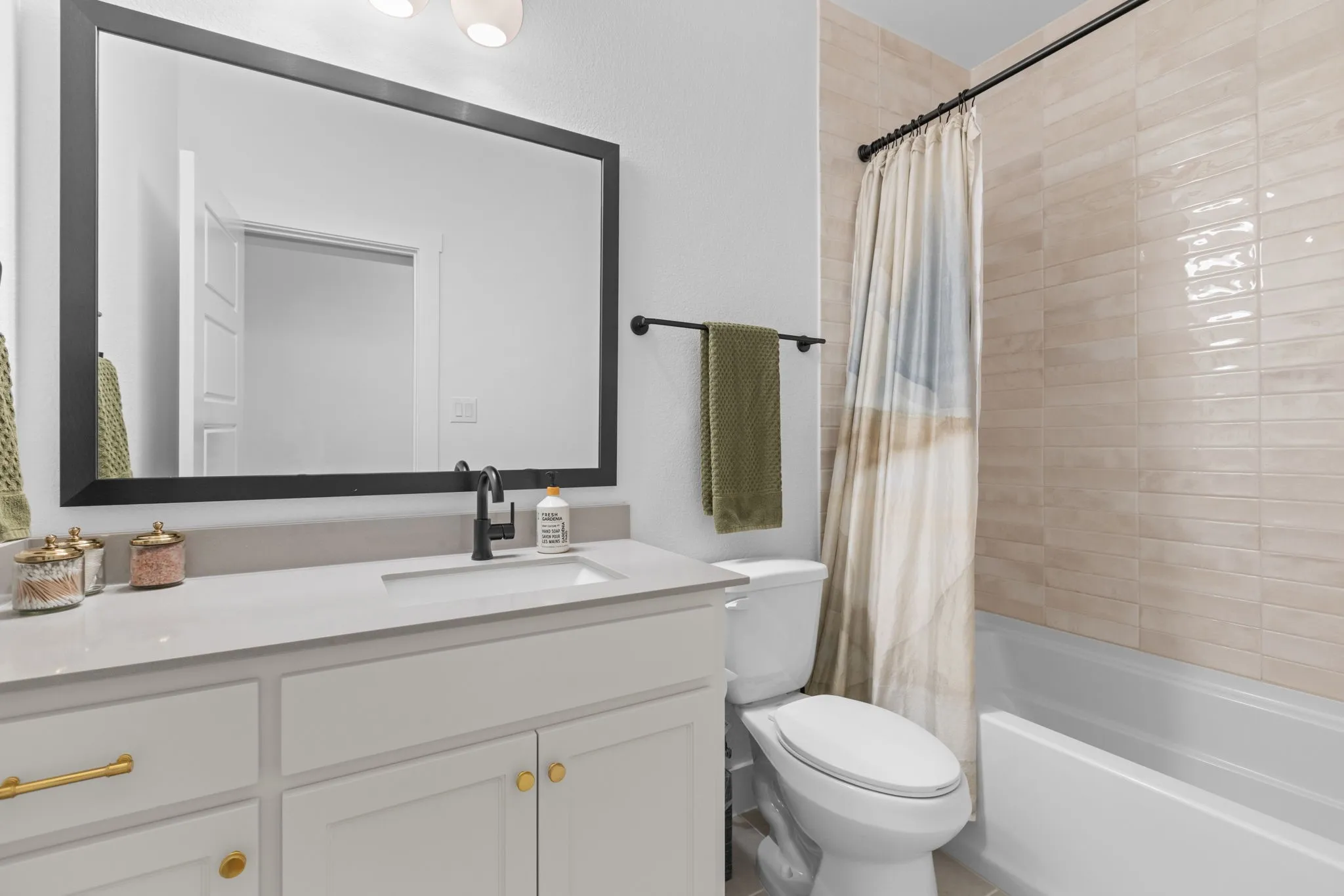 White vanity with gold-tone hardware, rectangular undermount sink, and dark-tone faucet
