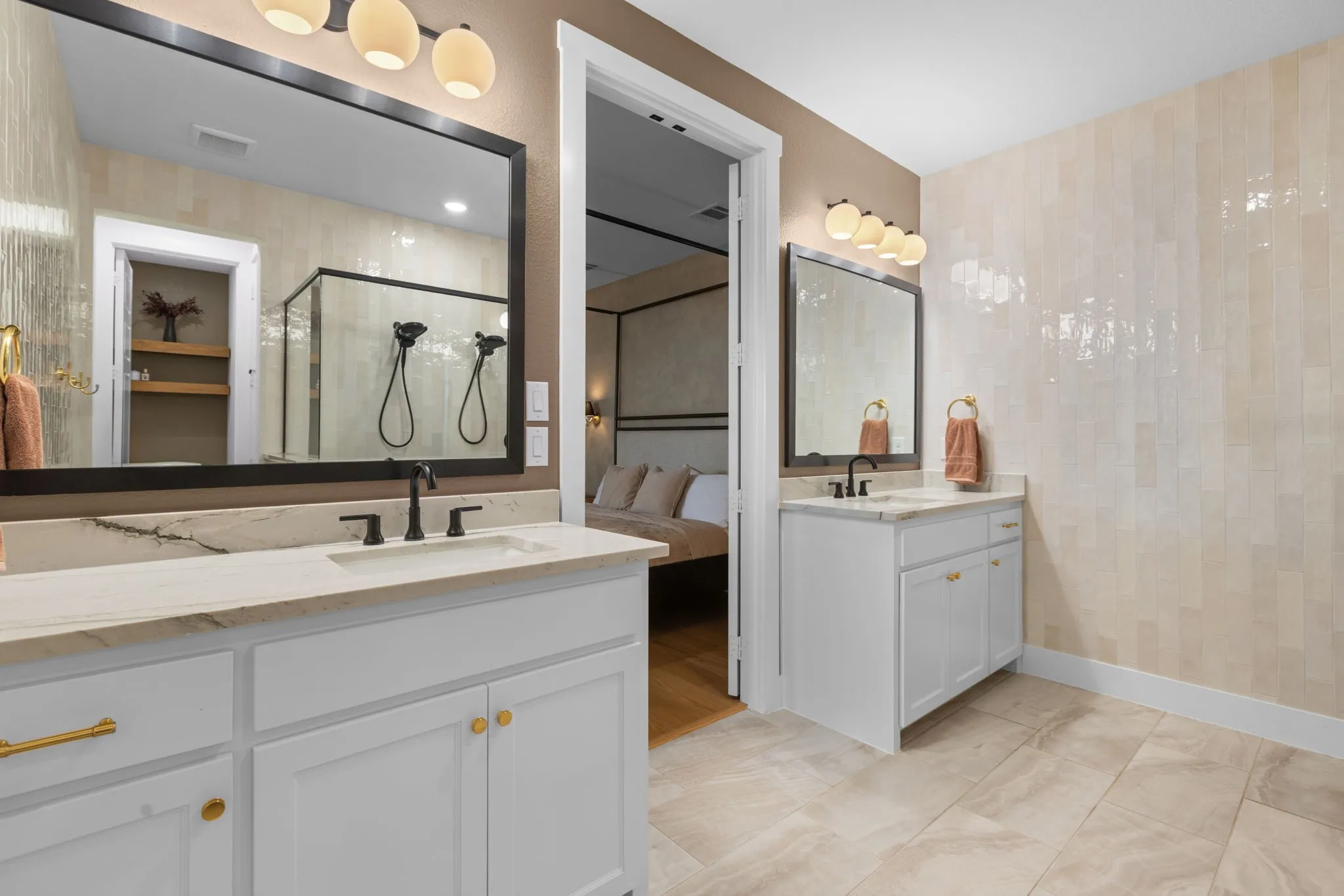 Dual vanity with white cabinetry, gold-finish hardware, and stone countertops