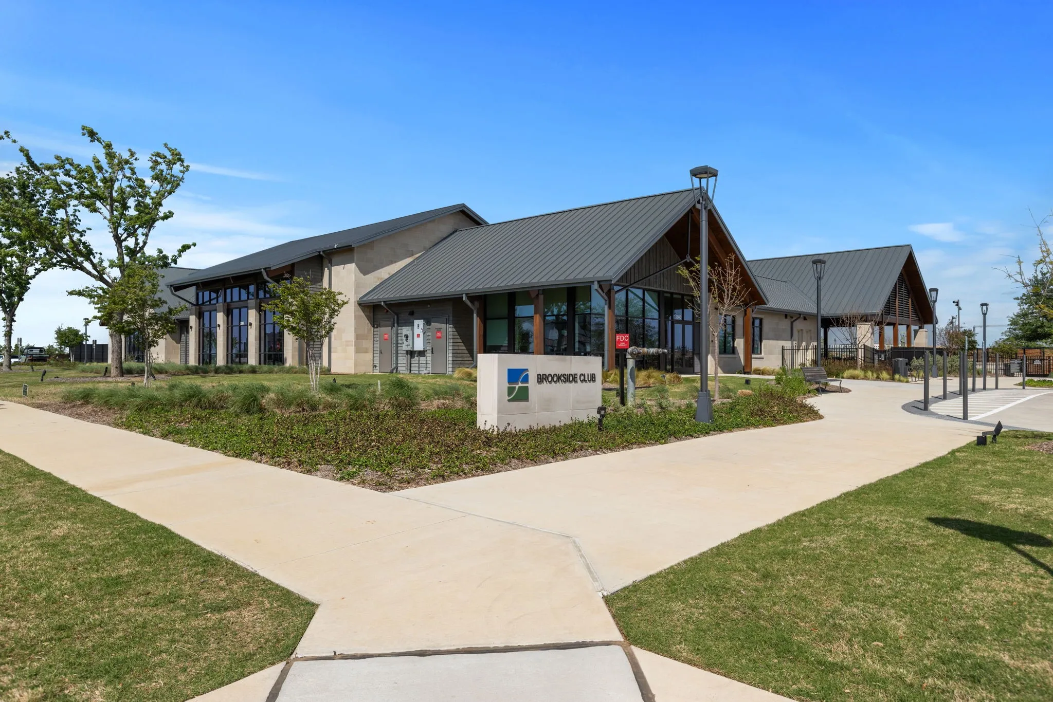 Modern club building featuring a standing seam metal roof and expansive window walls
