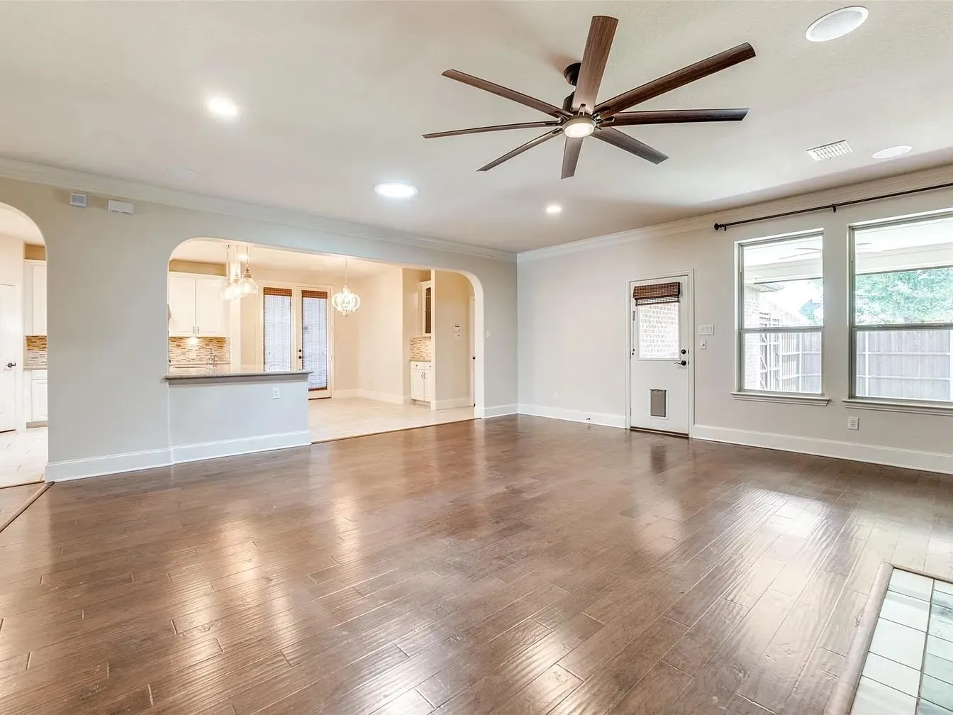 Spacious living area featuring wood-finish flooring, recessed lighting, and a modern ceiling fan