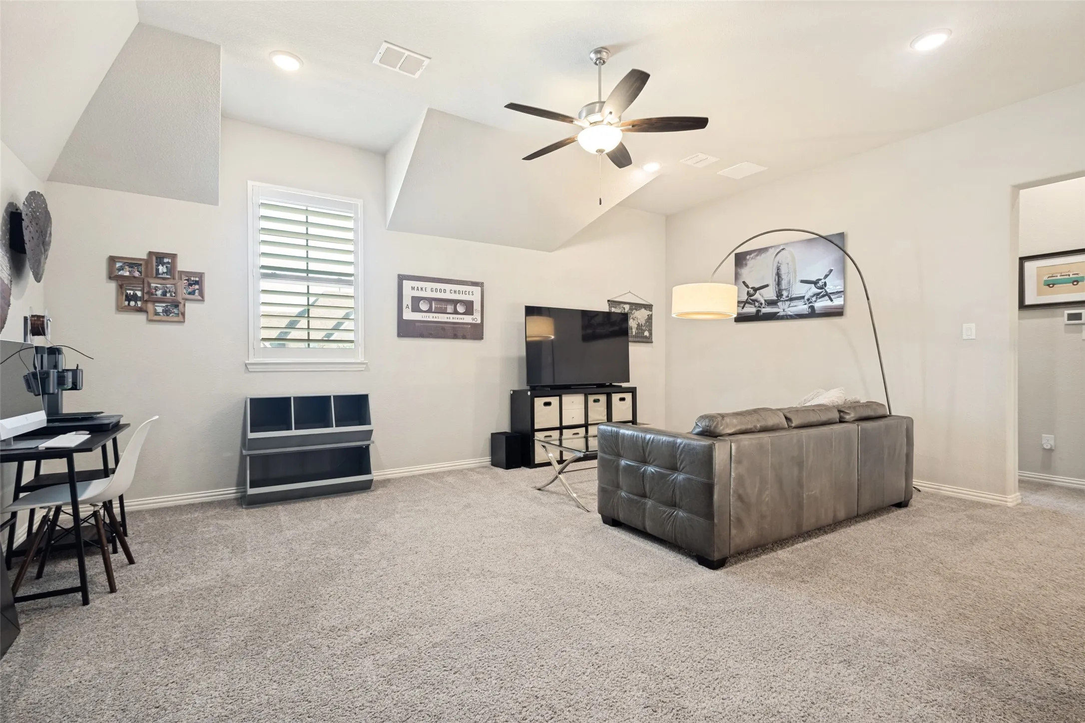 Spacious carpeted game room featuring high ceilings, recessed lighting, a window with plantation shutters open to the first floor. Plenty of room for a pool table or second living room or other style gaming room