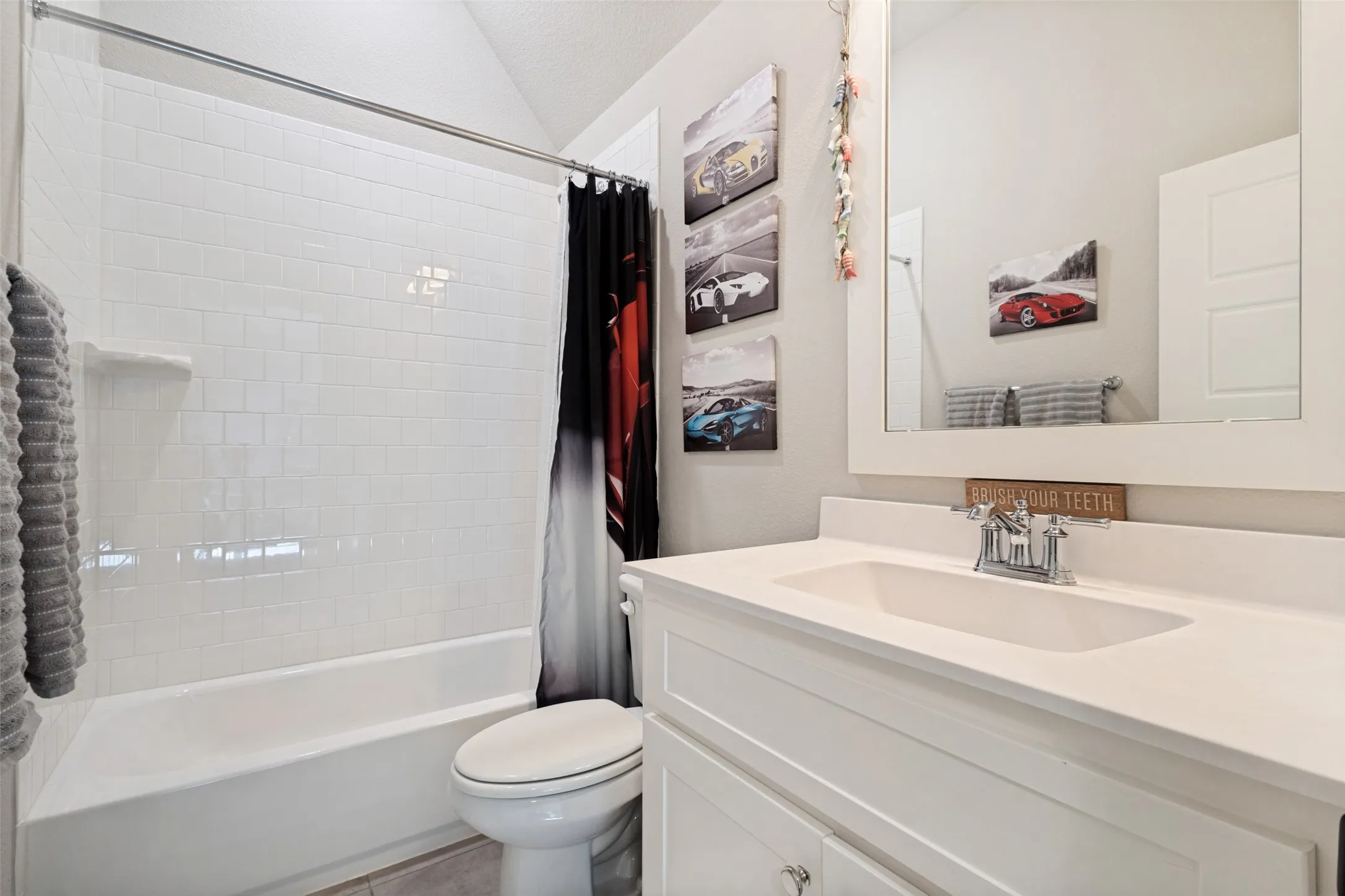 Bathroom featuring a white vanity with integrated sink, chrome faucet, and framed mirror