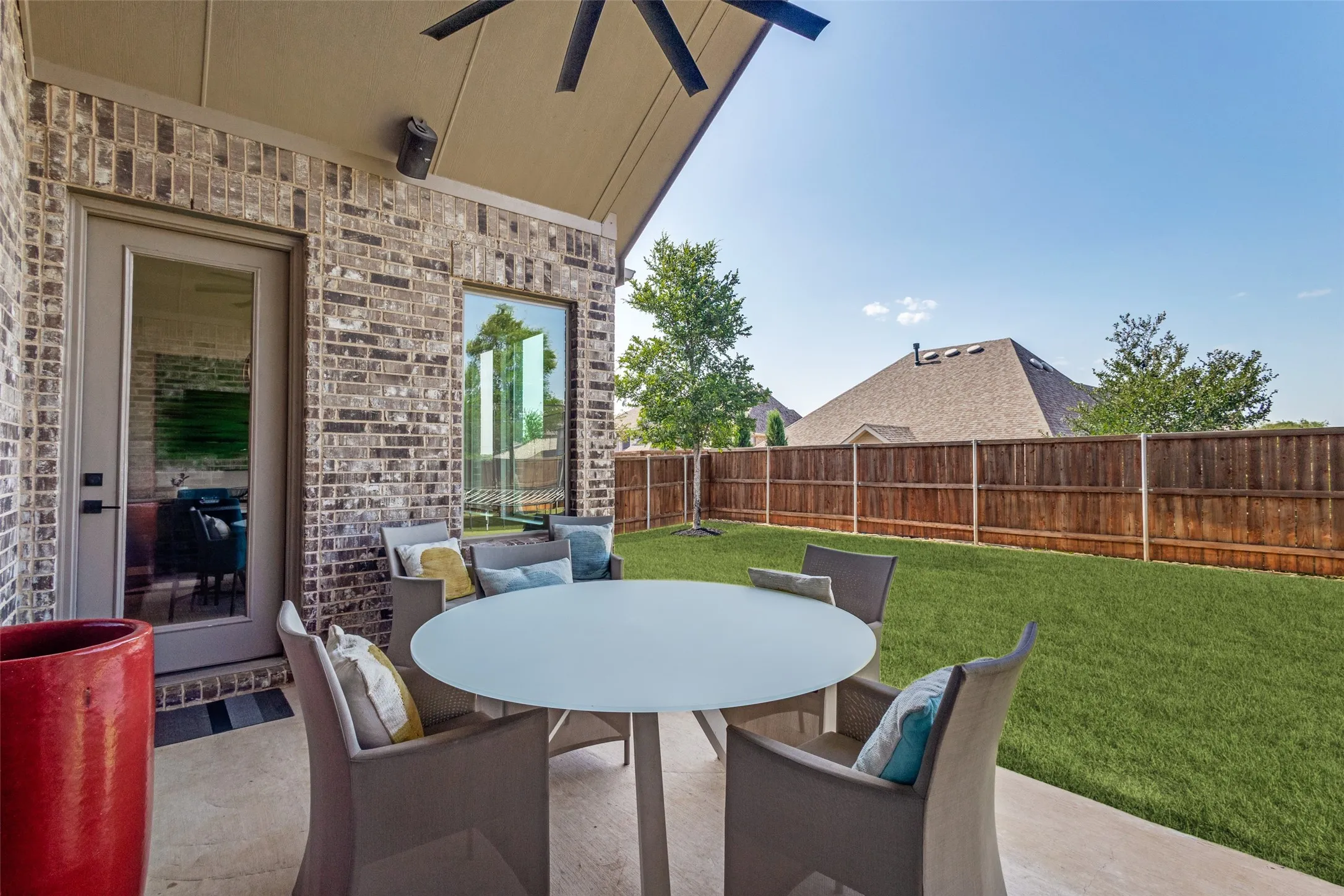 Covered patio with brick exterior, natural gas hookup for your grill, a large ceiling fan for those hot nights, and outdoor-grade 55" television with built-in outdoor speakers.