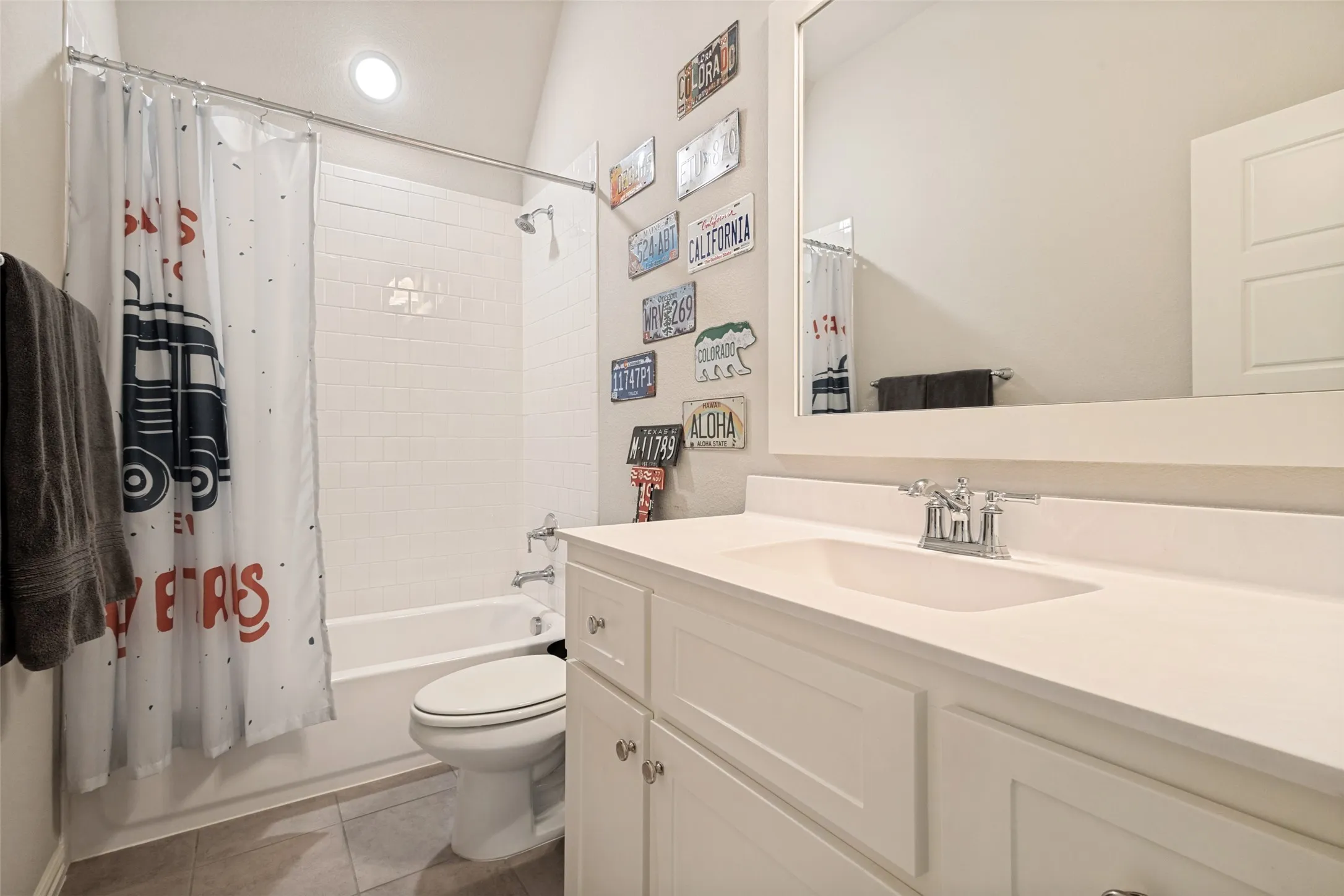 Bathroom featuring a white vanity with an integrated sink, polished chrome faucet, and framed mirror