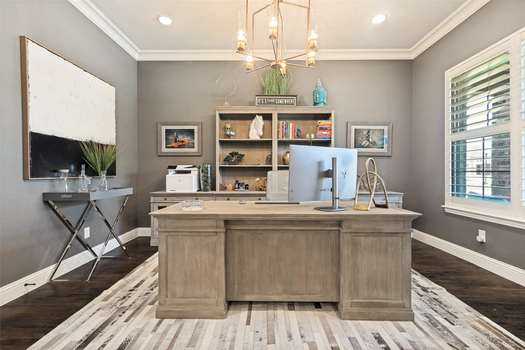Dedicated office space featuring dark solid hardwood flooring with crown molding, and a large window with plantation shutters