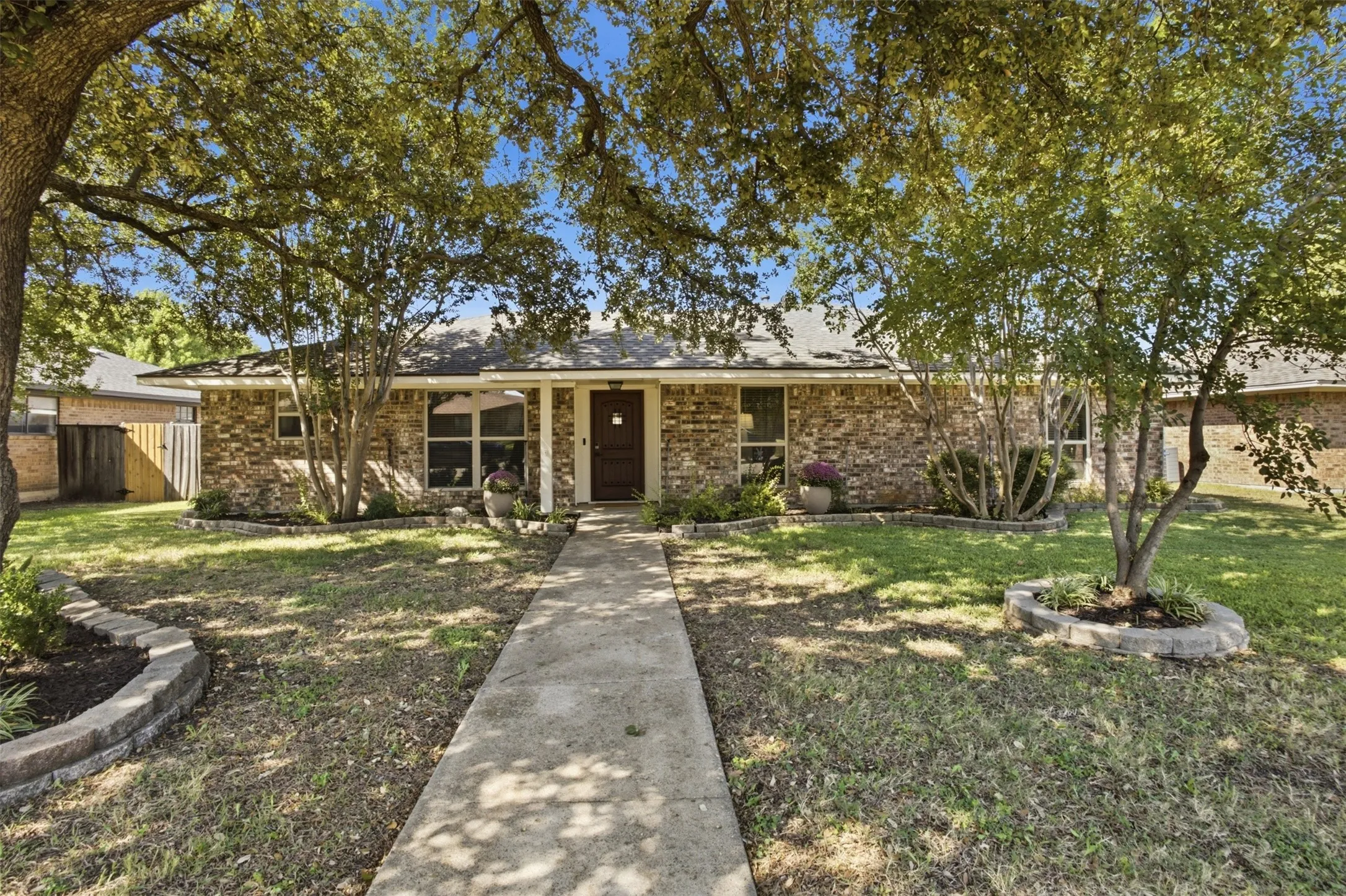 Charming front exterior with a walkway leading to the covered entry.