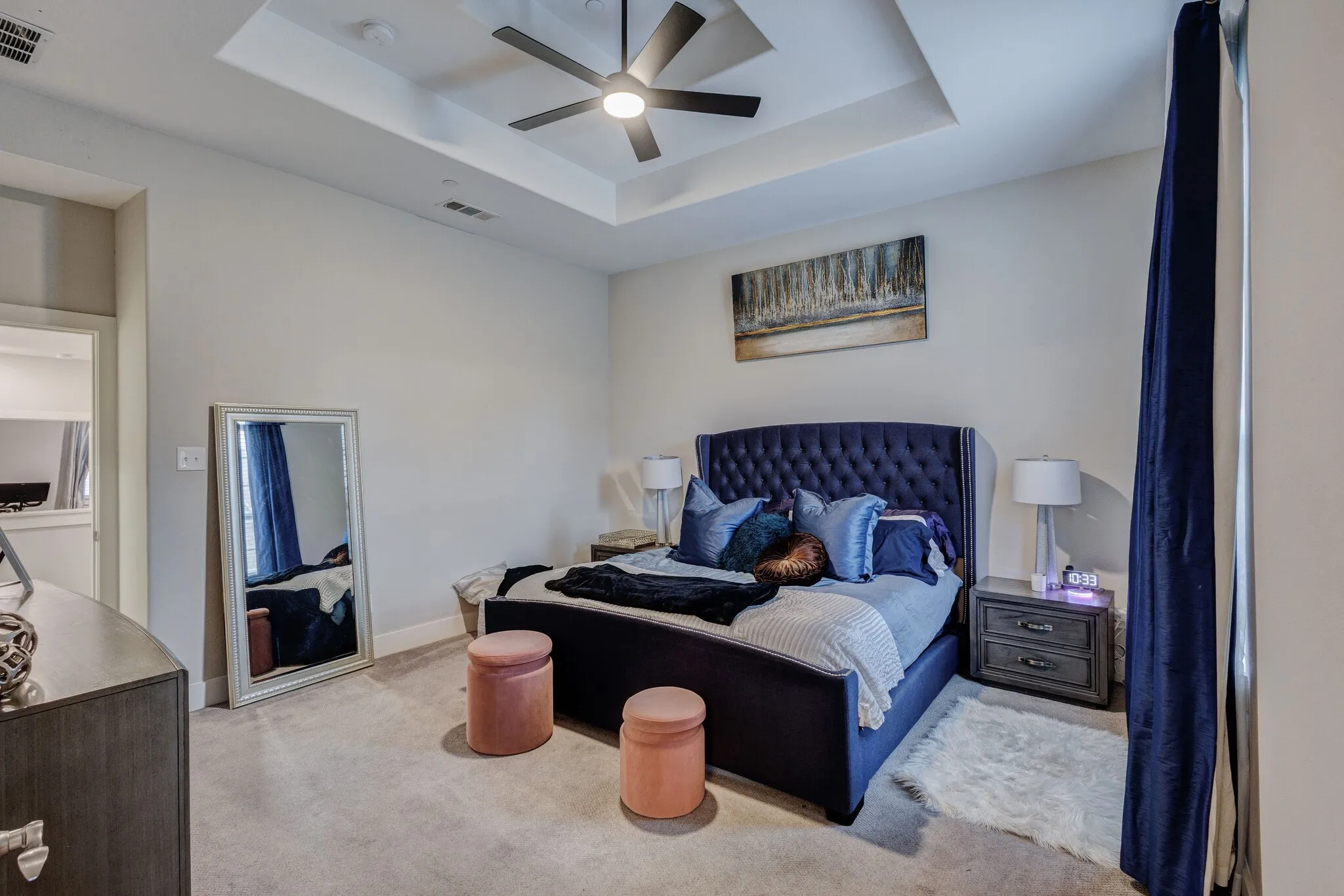 Recessed ceiling with an integrated ceiling fan, light-toned wall paint, and light-toned carpet flooring