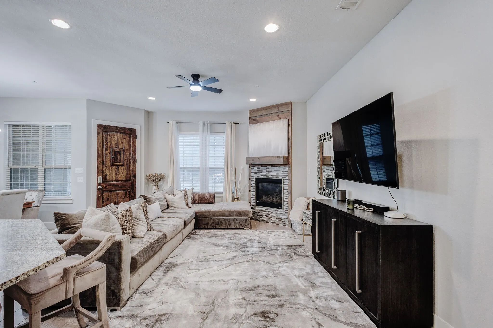 Recessed lighting, ceiling fan, wood-finish flooring, stone-faced fireplace with wood mantel, and granite-finish countertop