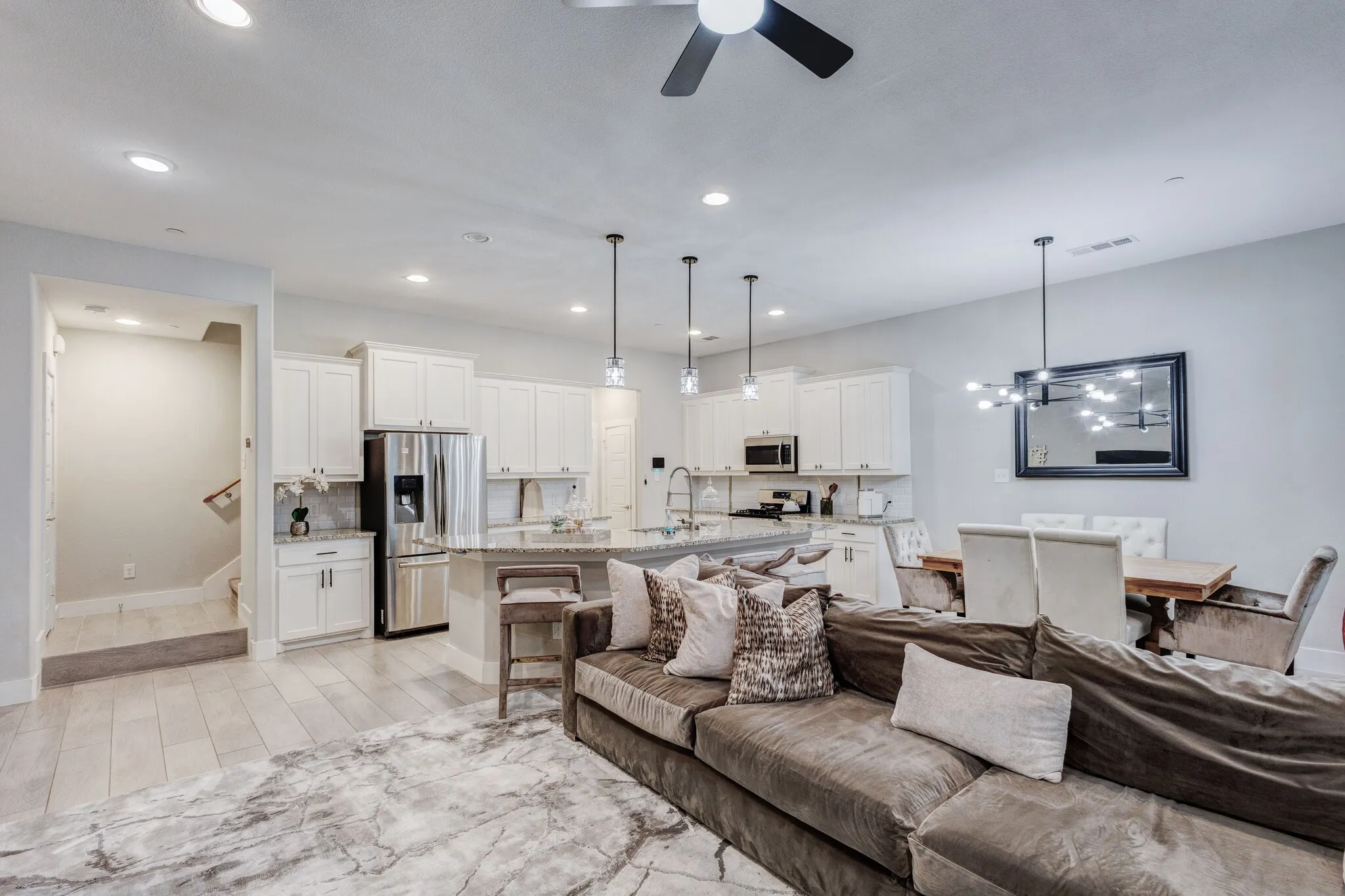 Open-concept living space with wood-finish flooring, recessed lighting, and a ceiling fan