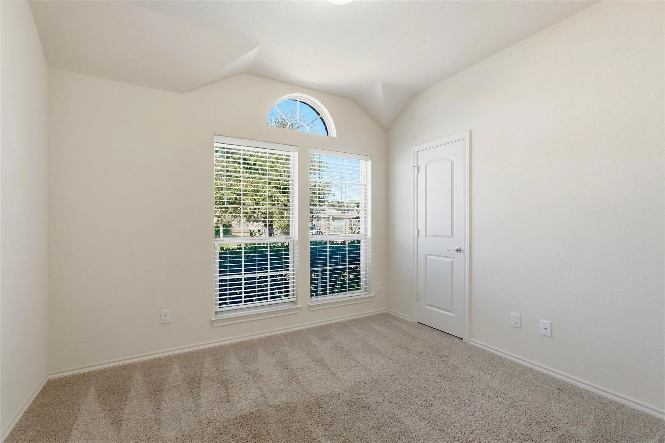 Neutral wall paint, arched window accent, and recessed lighting