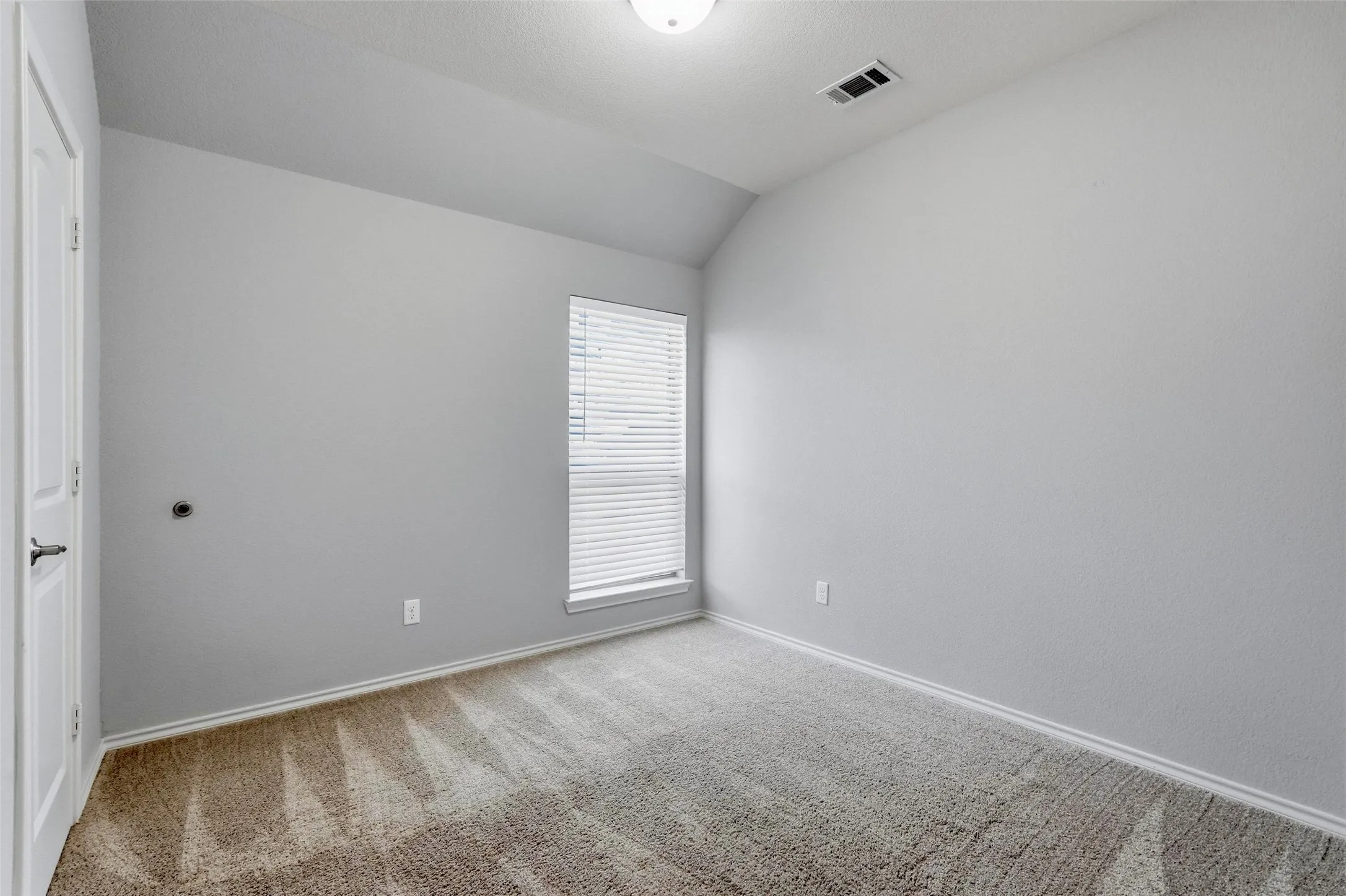 Wall-to-wall carpeting, window with blinds, and white trim