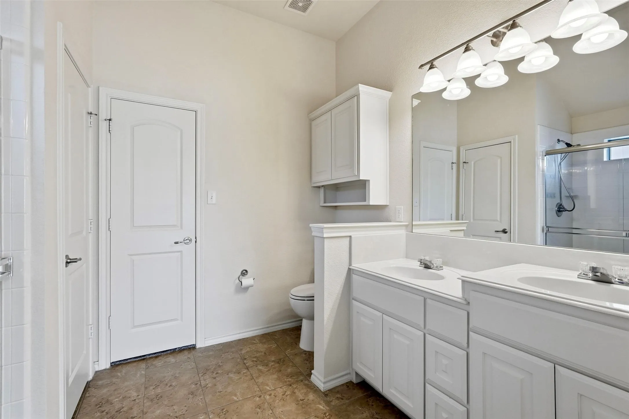 Dual vanity with integrated sinks, brushed nickel fixtures, wall-mounted mirror, and overhead lighting