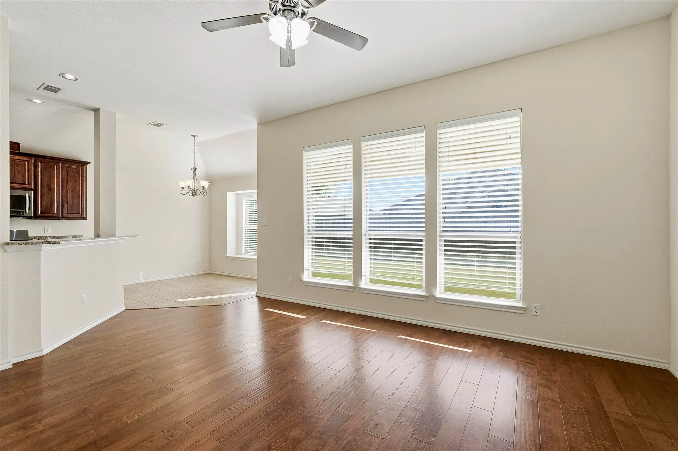 Wood-finish flooring, recessed lighting, and a ceiling fan with light fixture