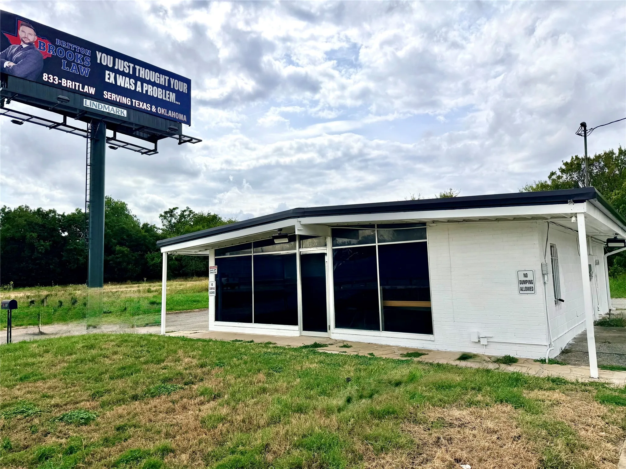 White exterior building with a flat roof, prominent front windows, and a covered entry