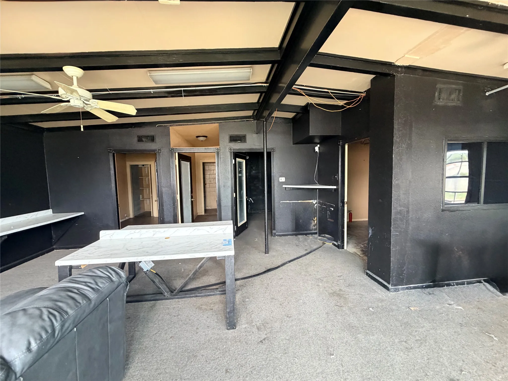 Exposed ceiling beams, recessed lighting, and a ceiling fan