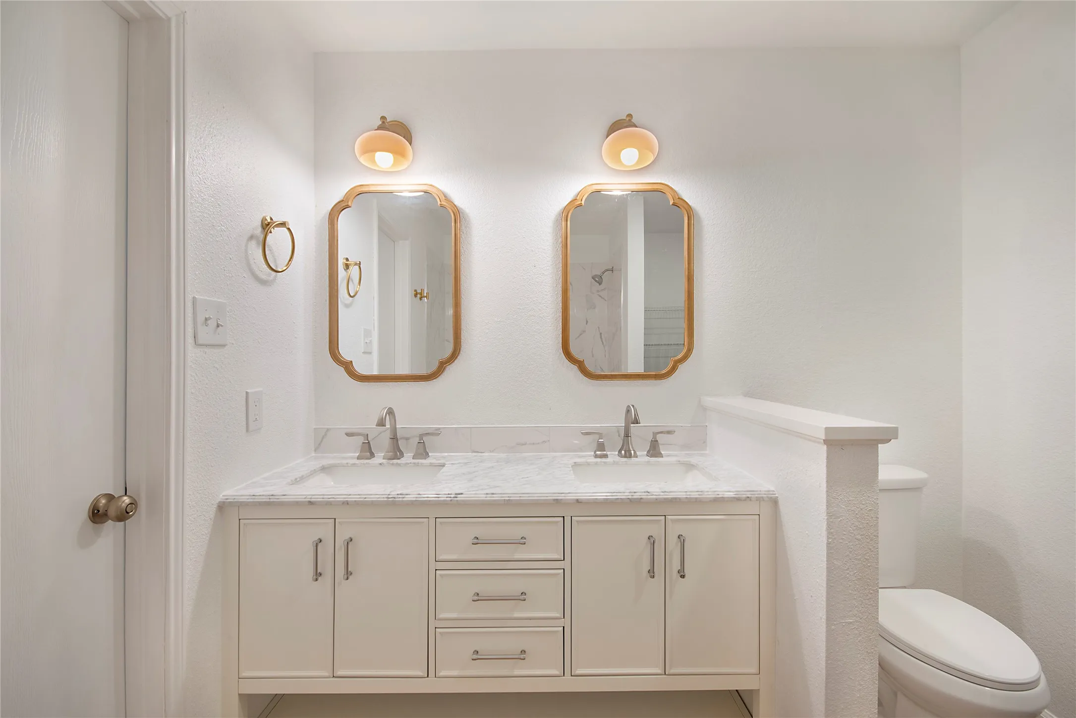 Dual vanity with undermount sinks, stone countertop, and brushed nickel fixtures