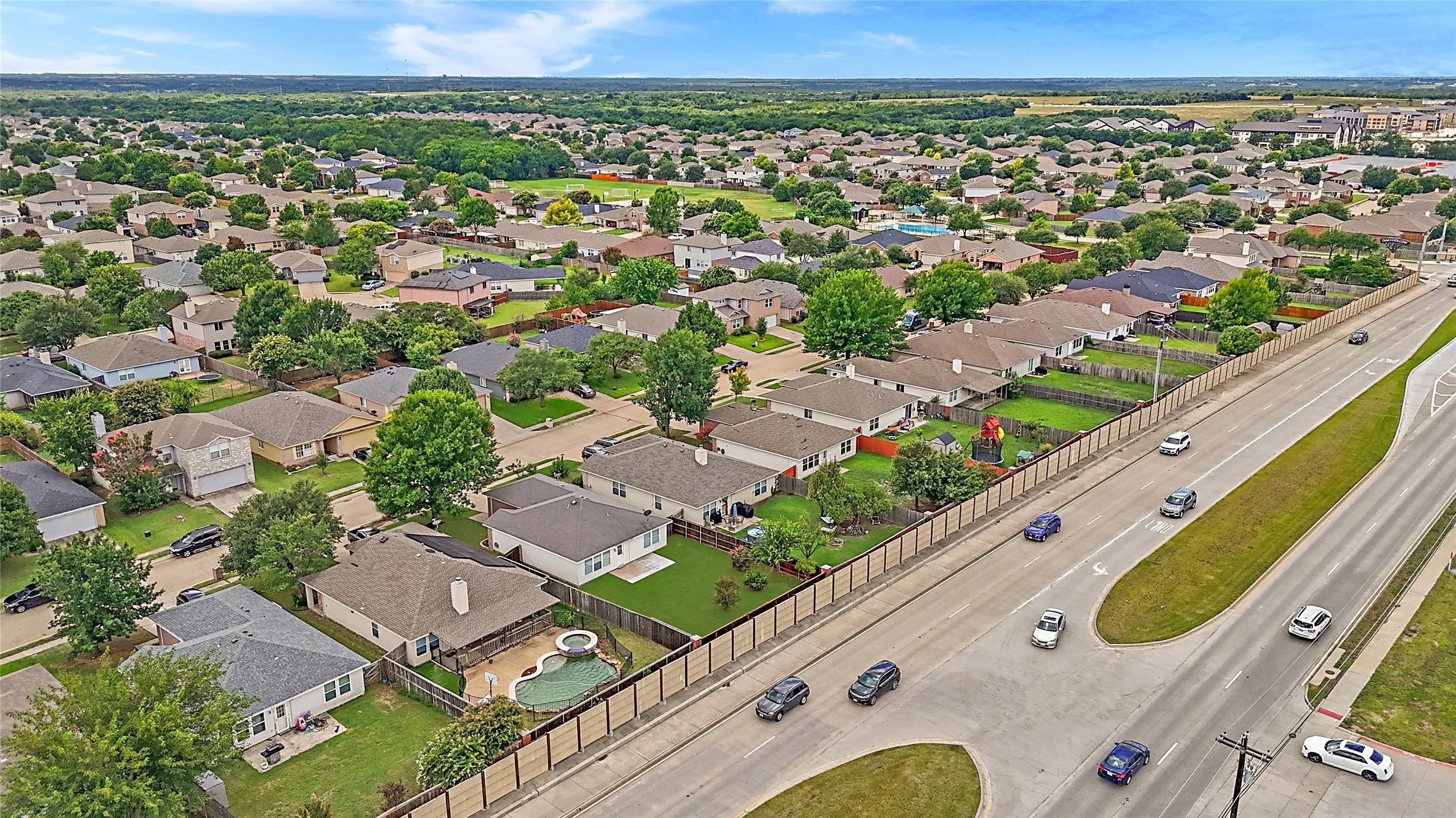 Expansive suburban landscape with numerous residential properties, mature trees, and an accessible thoroughfare