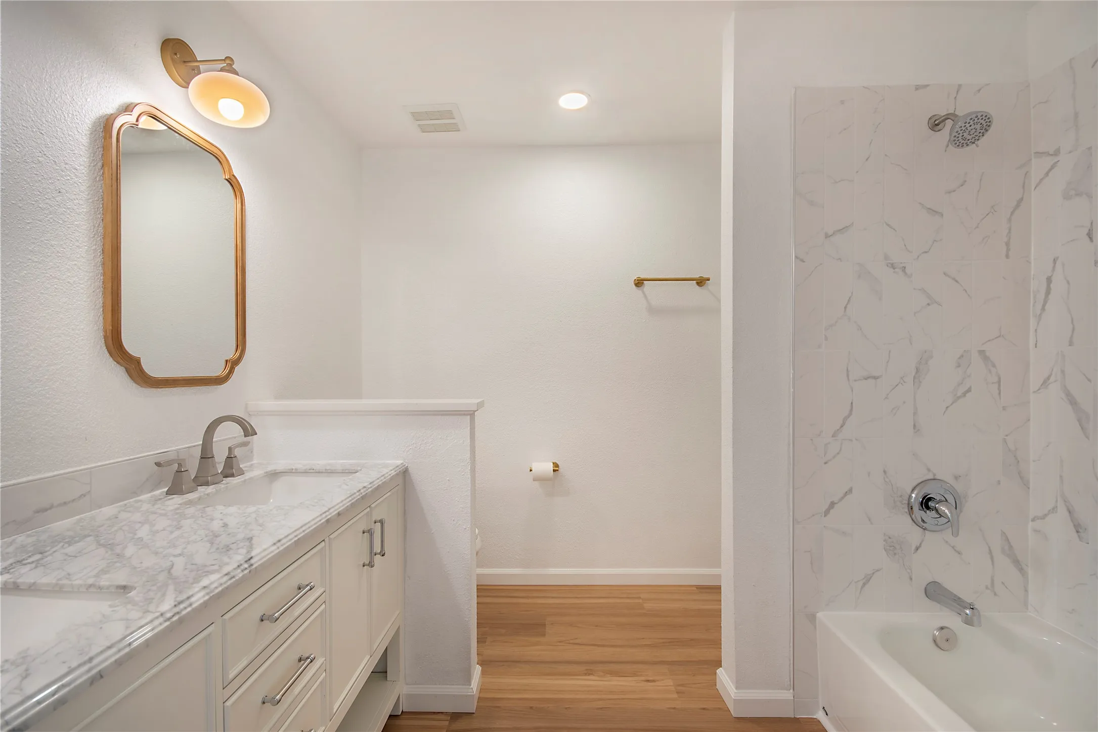 White vanity with a stone-finish countertop, dual under-mount sinks, and brushed nickel fixtures