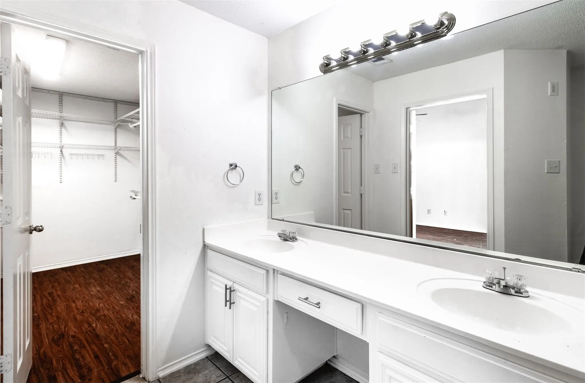 Dual vanity with integrated sinks, expansive mirror, and a built-in makeup counter
